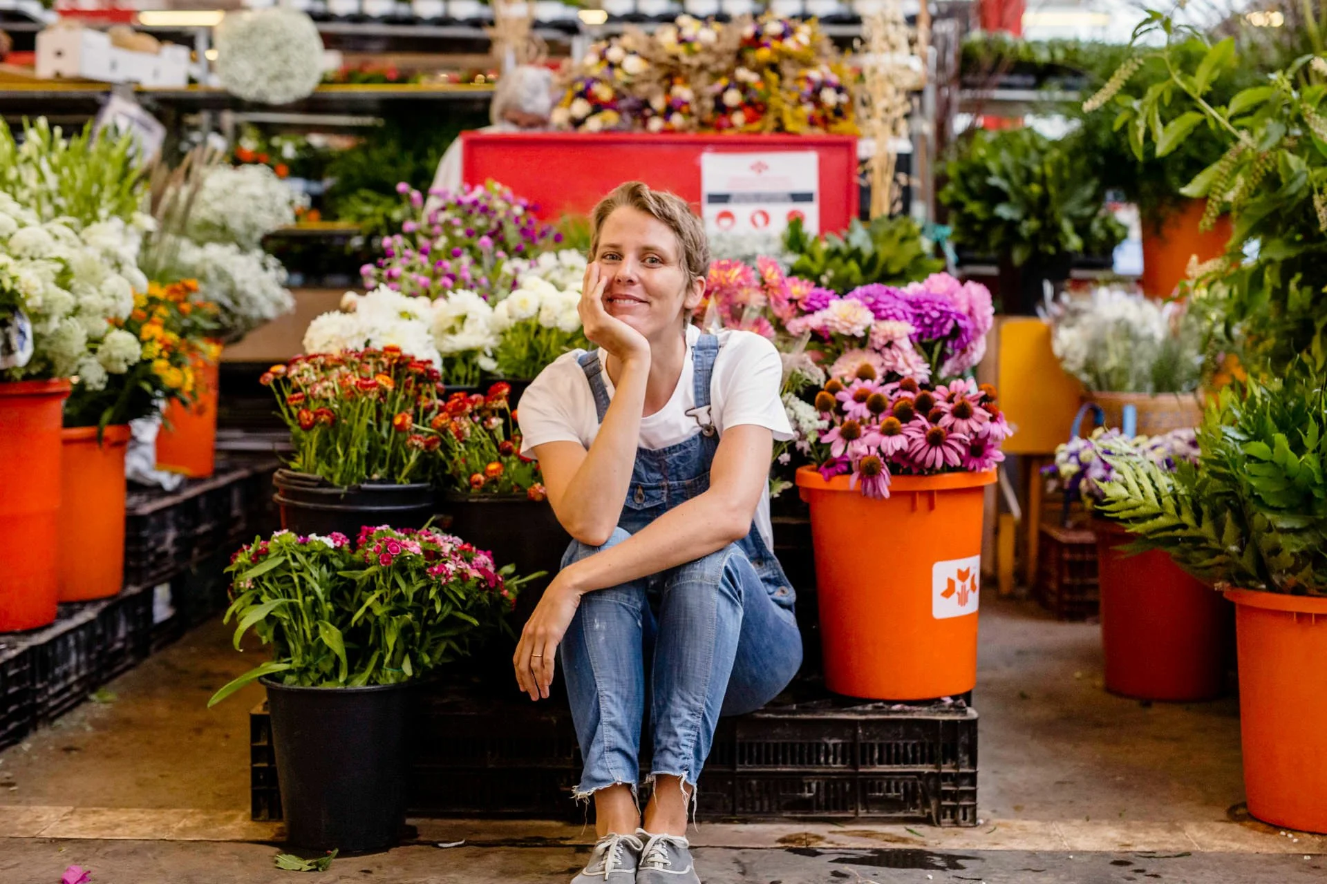 Floral designer Margaux Bastid surrounded by fresh flowers at the local Barcelona market, sourcing seasonal blooms for international events