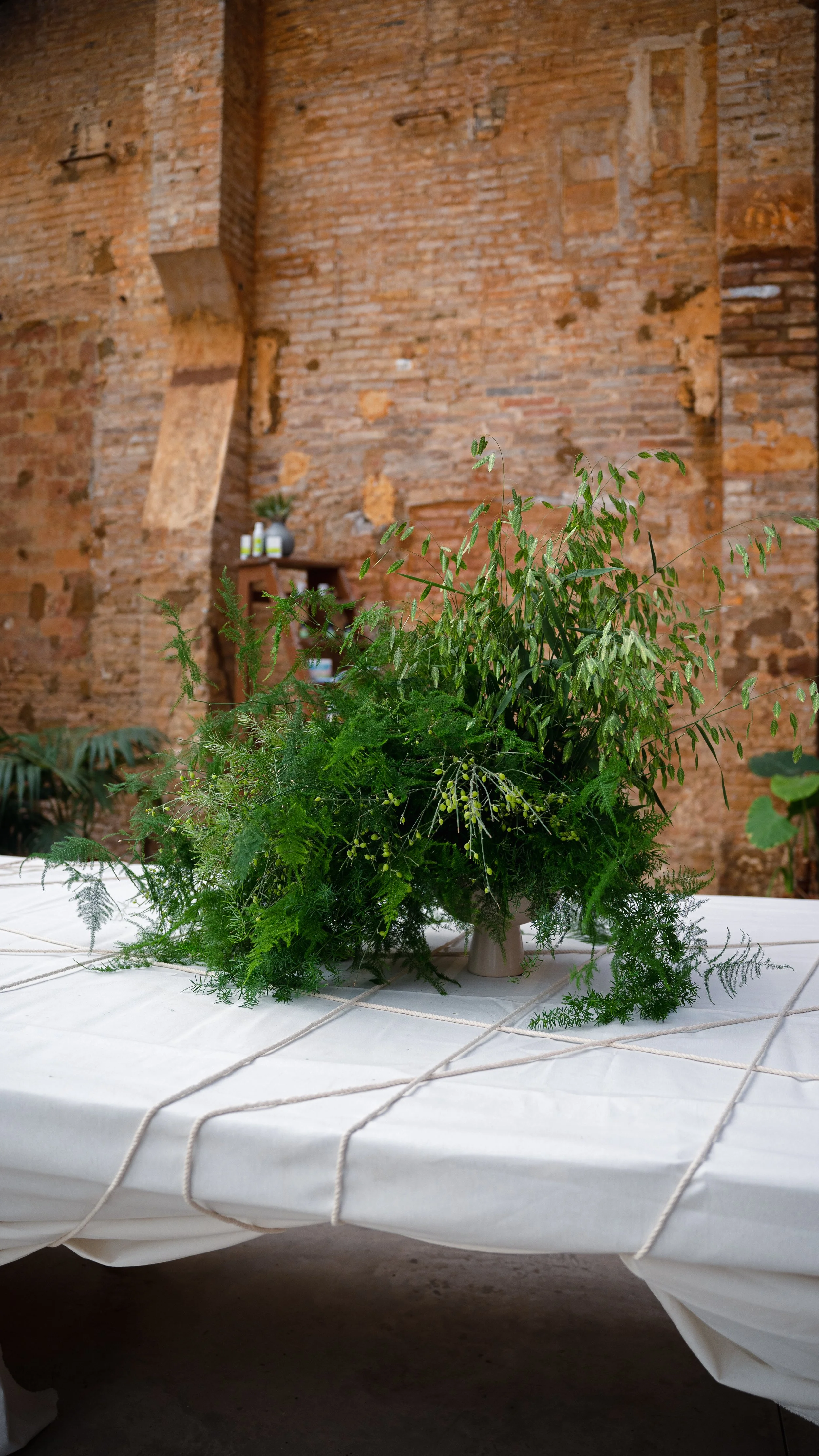 Luxury botanical table installation featuring abundant seasonal foliage created for the Pranarôm x HerbalGem event at Flowers by Bornay in Barcelona