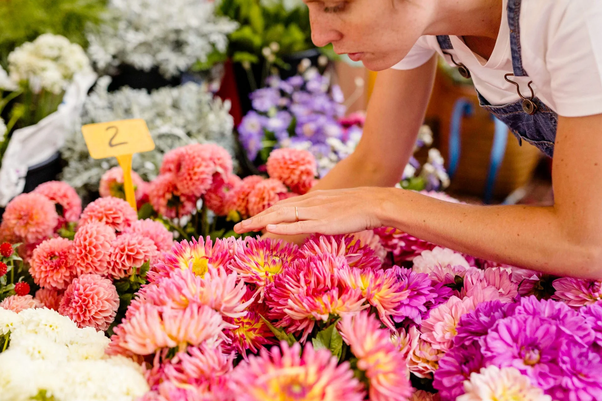 Florist smelling fresh seasonal flowers at the Barcelona market, Mosaic Flowers preparing for destination event designs