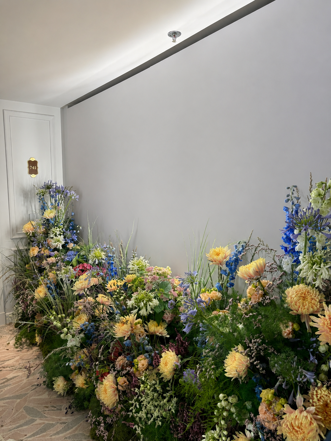 Generous floral installation created by Mosaic Flowers for a Ritz-Carlton suite in Cannes, showcasing artistic seasonal flowers for an international luxury brand event