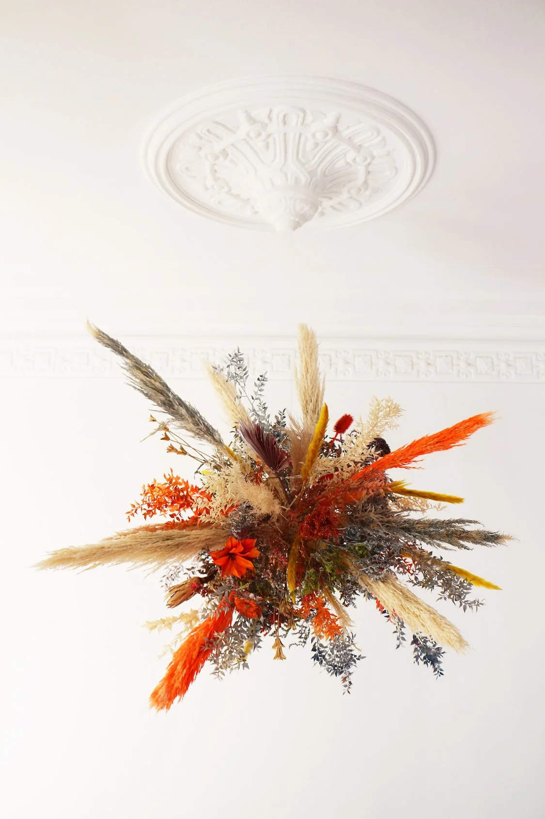 Suspended floral installation with warm tones hanging from the ceiling in a luxury flat in Barcelona’s Eixample, created by Mosaic