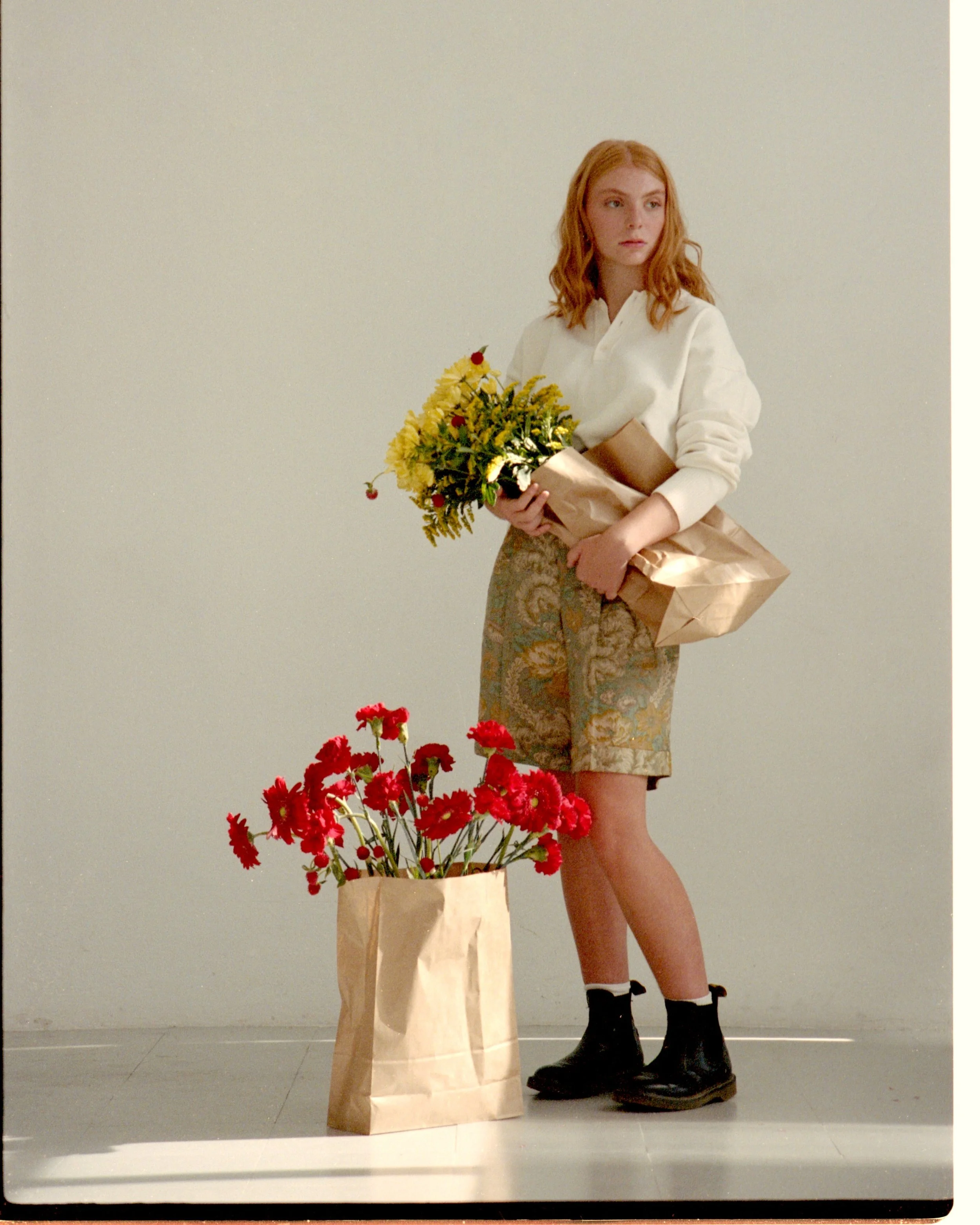 Fashion editorial in Barcelona with a model carrying grocery bags of fresh flowers, styled by Mosaic