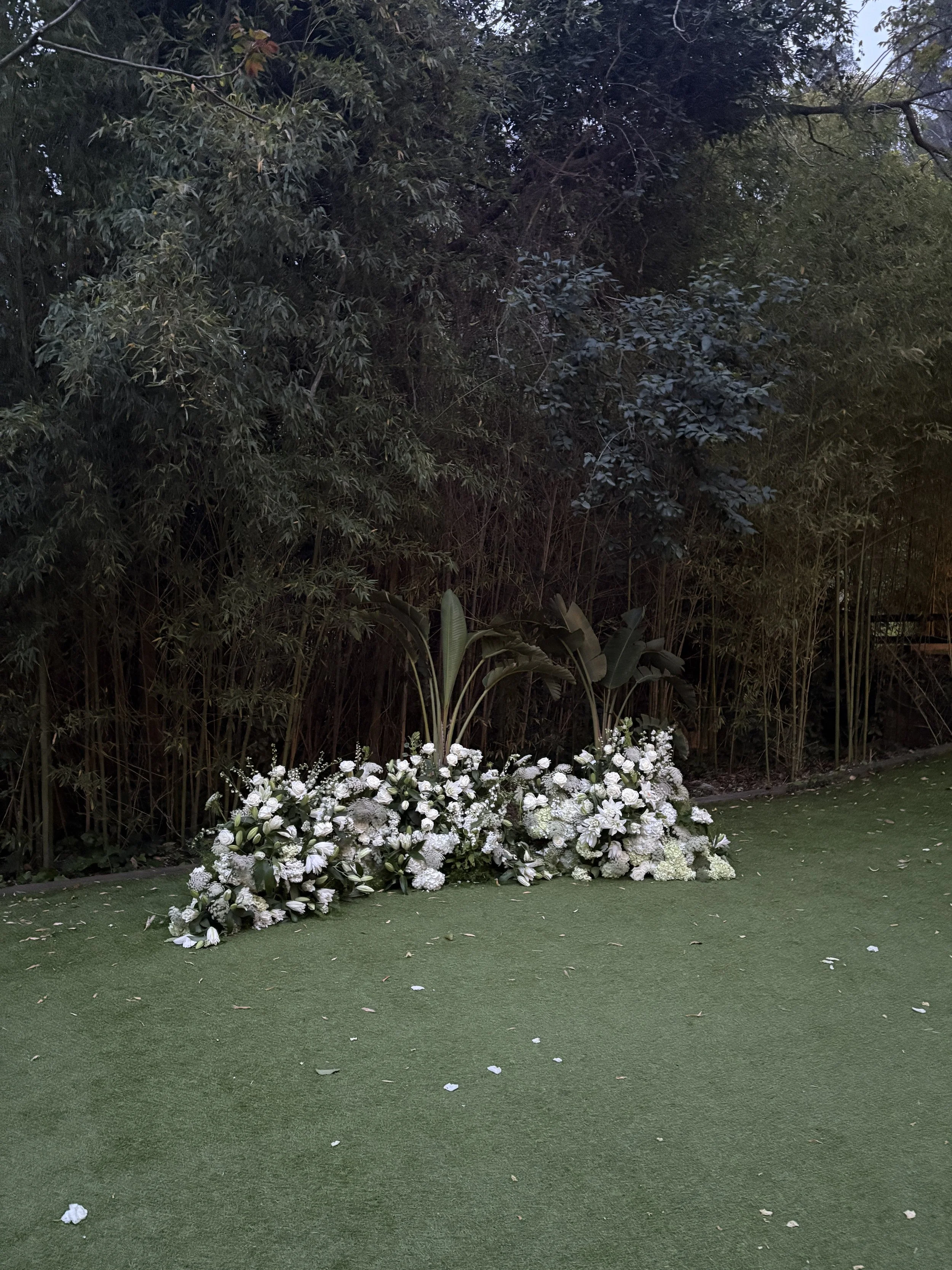 Bespoke floral ceremony installation with abundant white flowers created for Christie and Andrew's luxury wedding at Villa Almanita, a prestigious luxury masia in Catalunya, blending timeless elegance with contemporary floral artistry