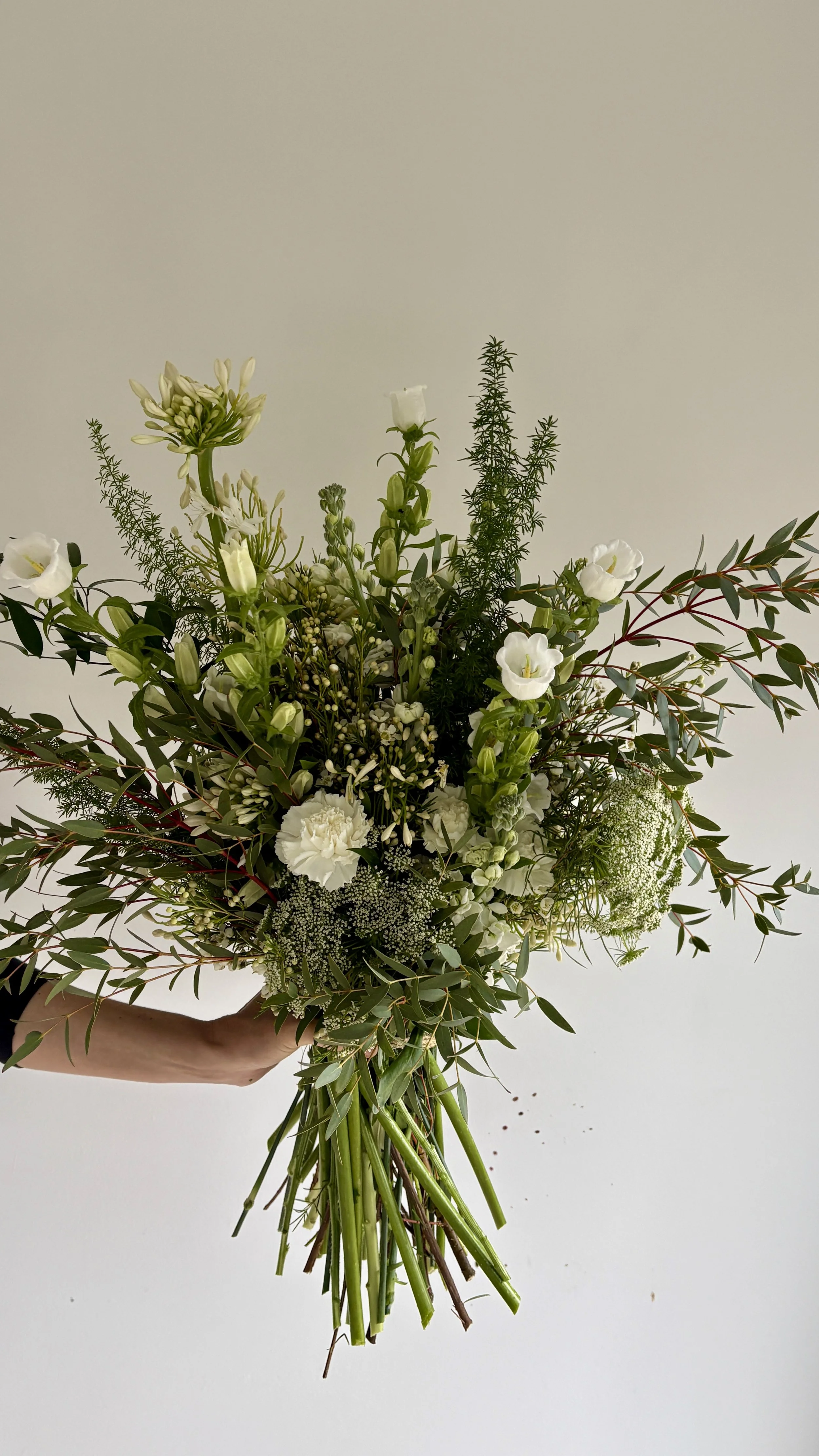 Contemporary handcrafted floral bouquet designed for VIP gifting in Barcelona, combining delicate white flowers and natural greenery with modern luxury styling