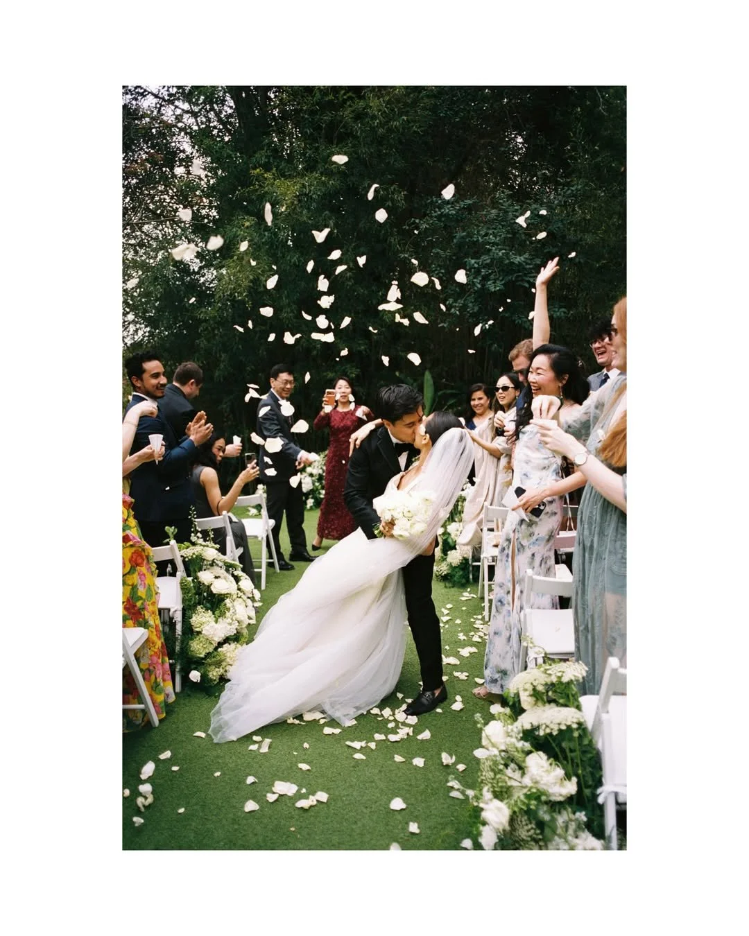 Christie and Andrew celebrating their wedding ceremony surrounded by bespoke floral installations and cascading white flower petals at Villa Almanita