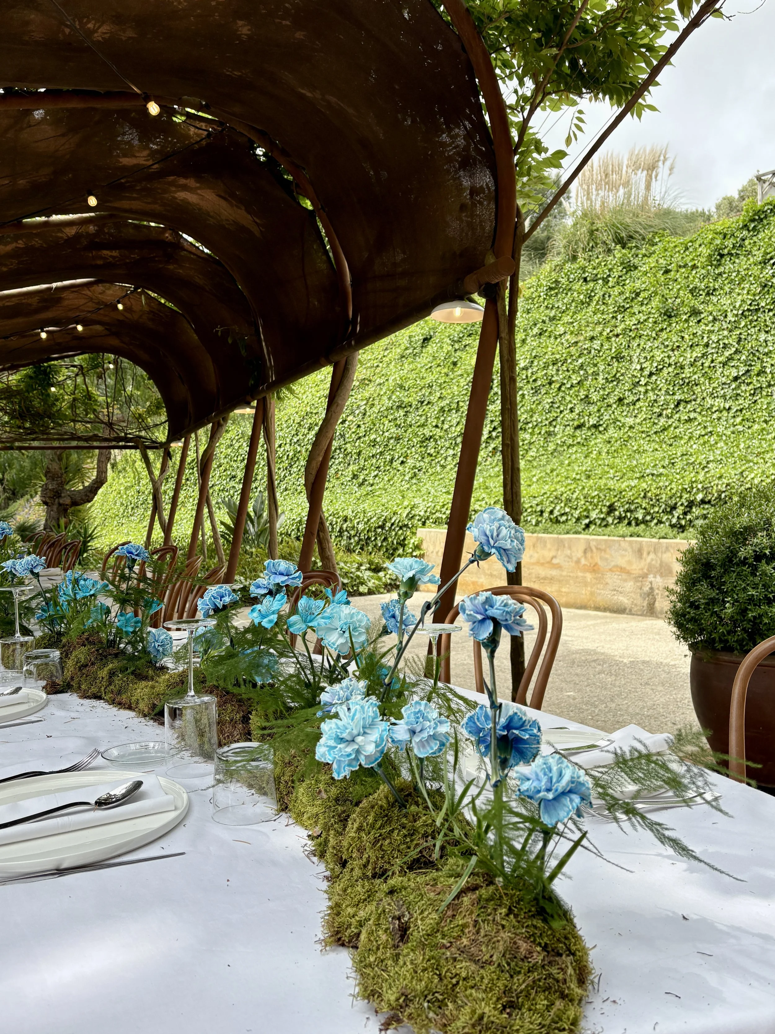Luxury tablescape with sculptural blue floral arrangements and a handcrafted moss runner created for the ASICS event in an exclusive countryside venue near Barcelona