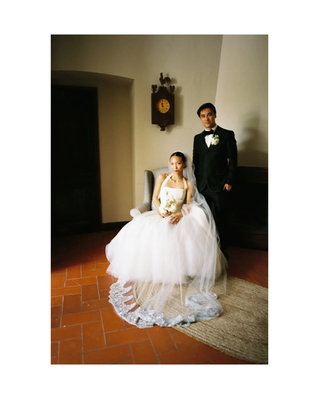Romantic portrait of Christie and Andrew surrounded by bespoke floral designs created for their luxury wedding celebration