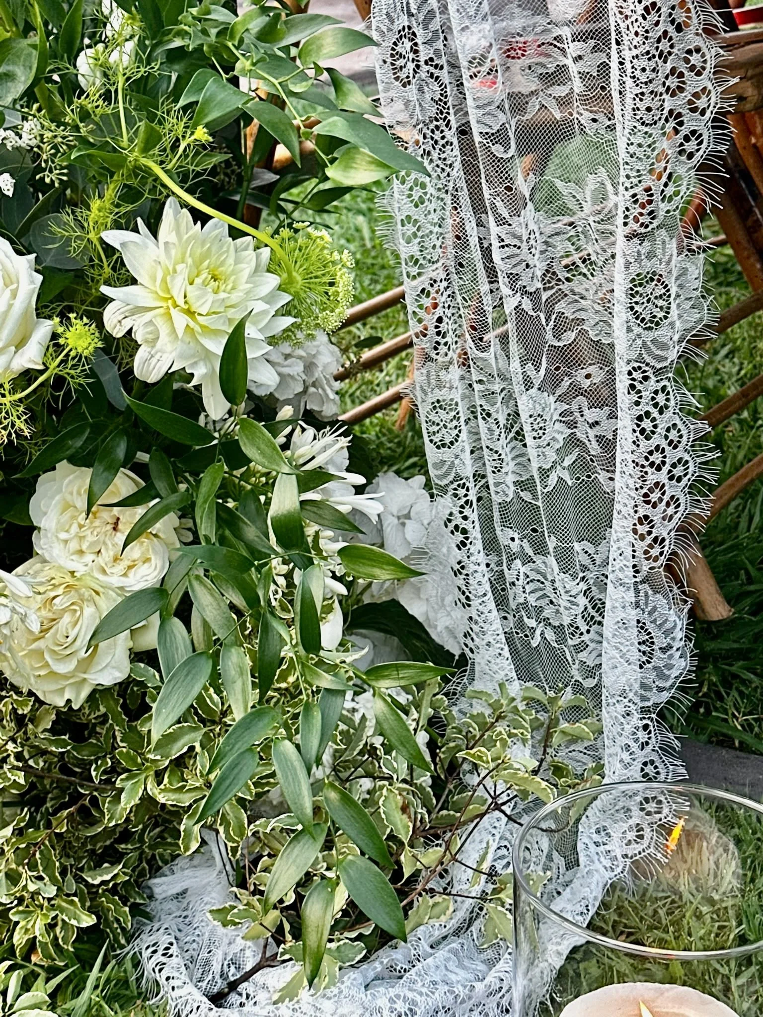 Elegant floral scenography created by Mosaic for Megan and Shane’s luxury wedding at Cortal Gran in Catalonia, combining lush greenery, white flowers and delicate lace-inspired textures