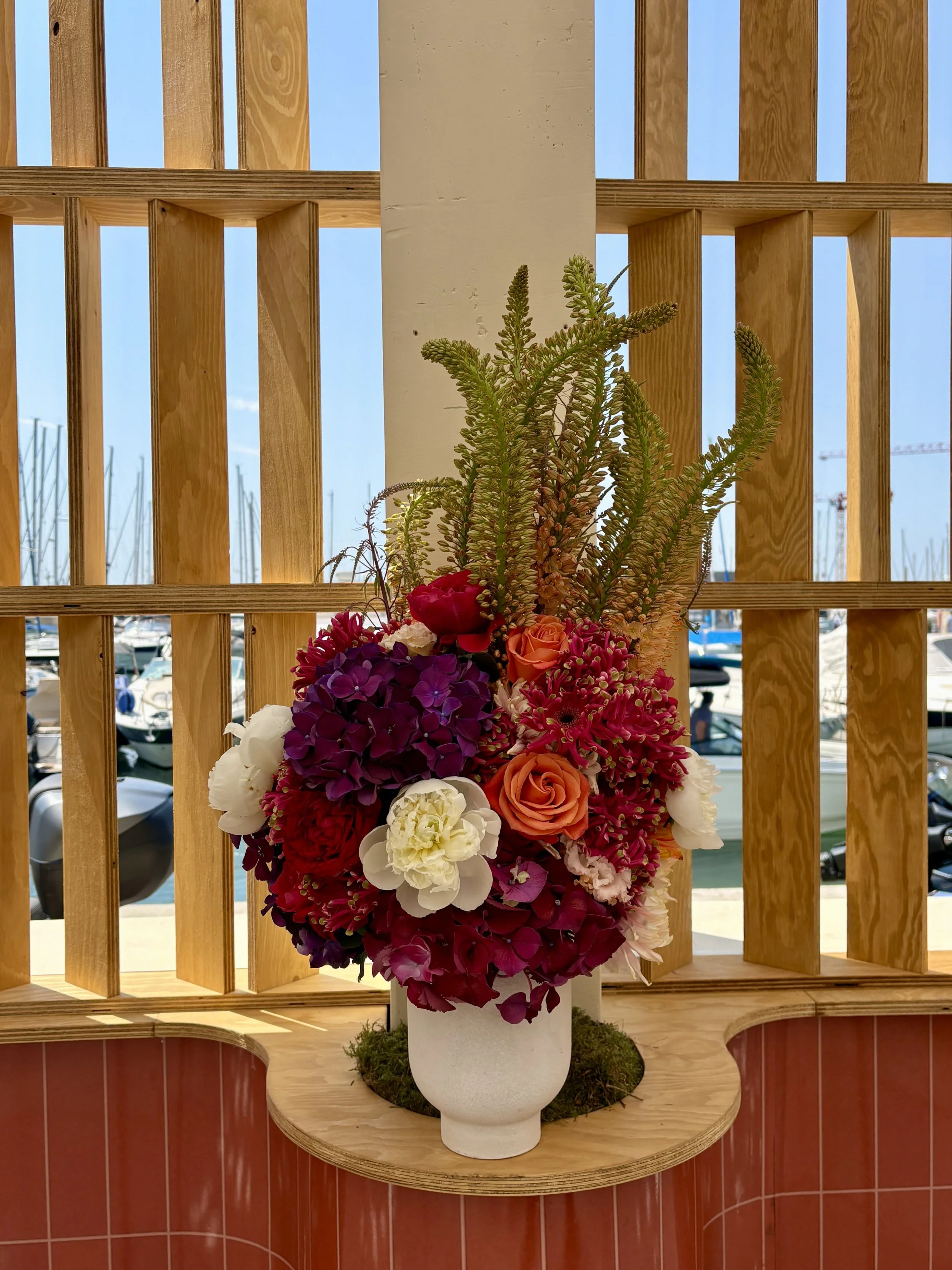 Sculptural floral composition with vibrant seasonal flowers and premium foliage created for Amazon's Cannes Lions event space