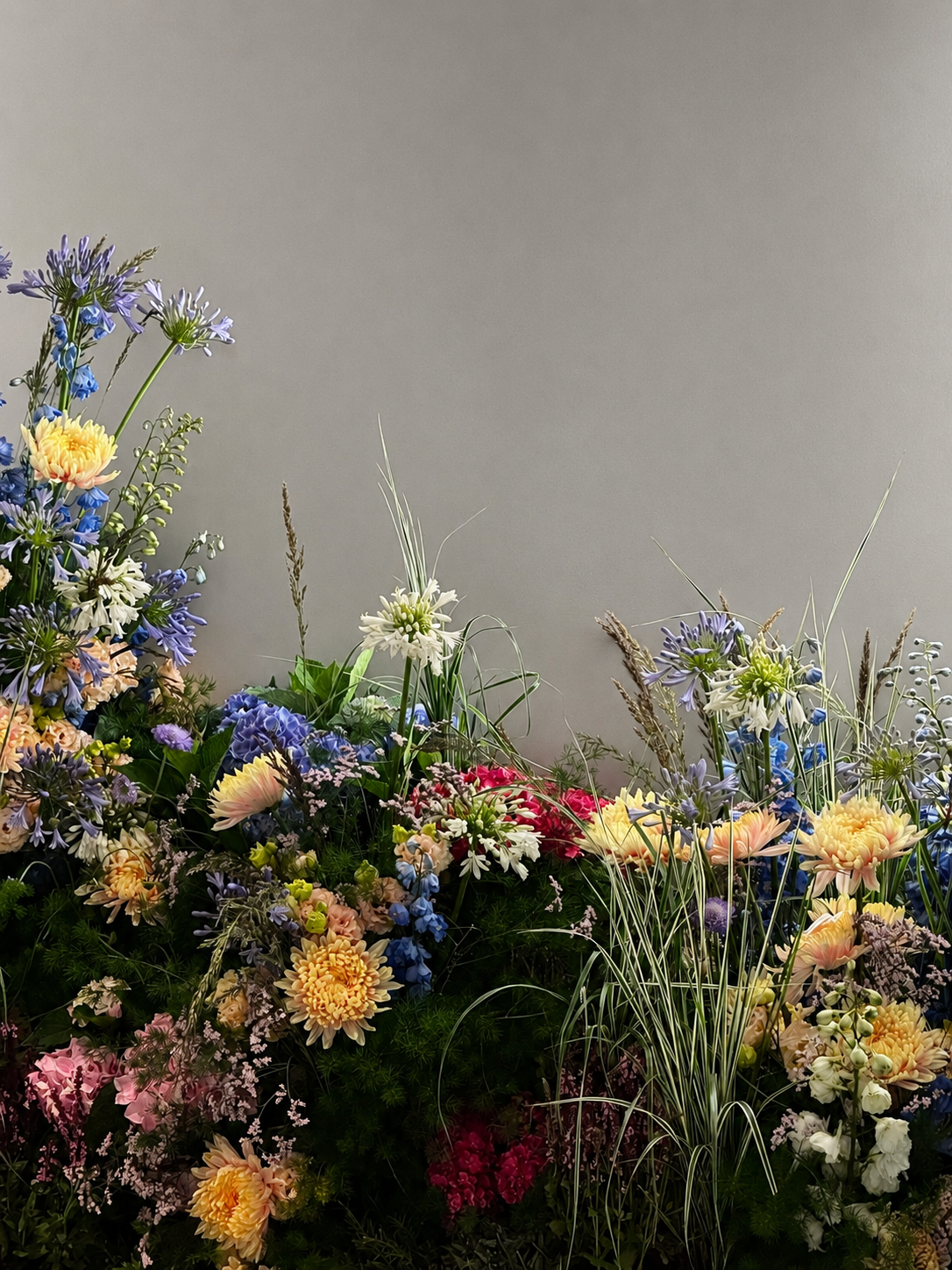 Close-up of a luxury floral backdrop designed by Mosaic Flowers for a Ritz-Carlton suite in Cannes, featuring abundant seasonal blooms in a creative installation by the Barcelona floral studio
