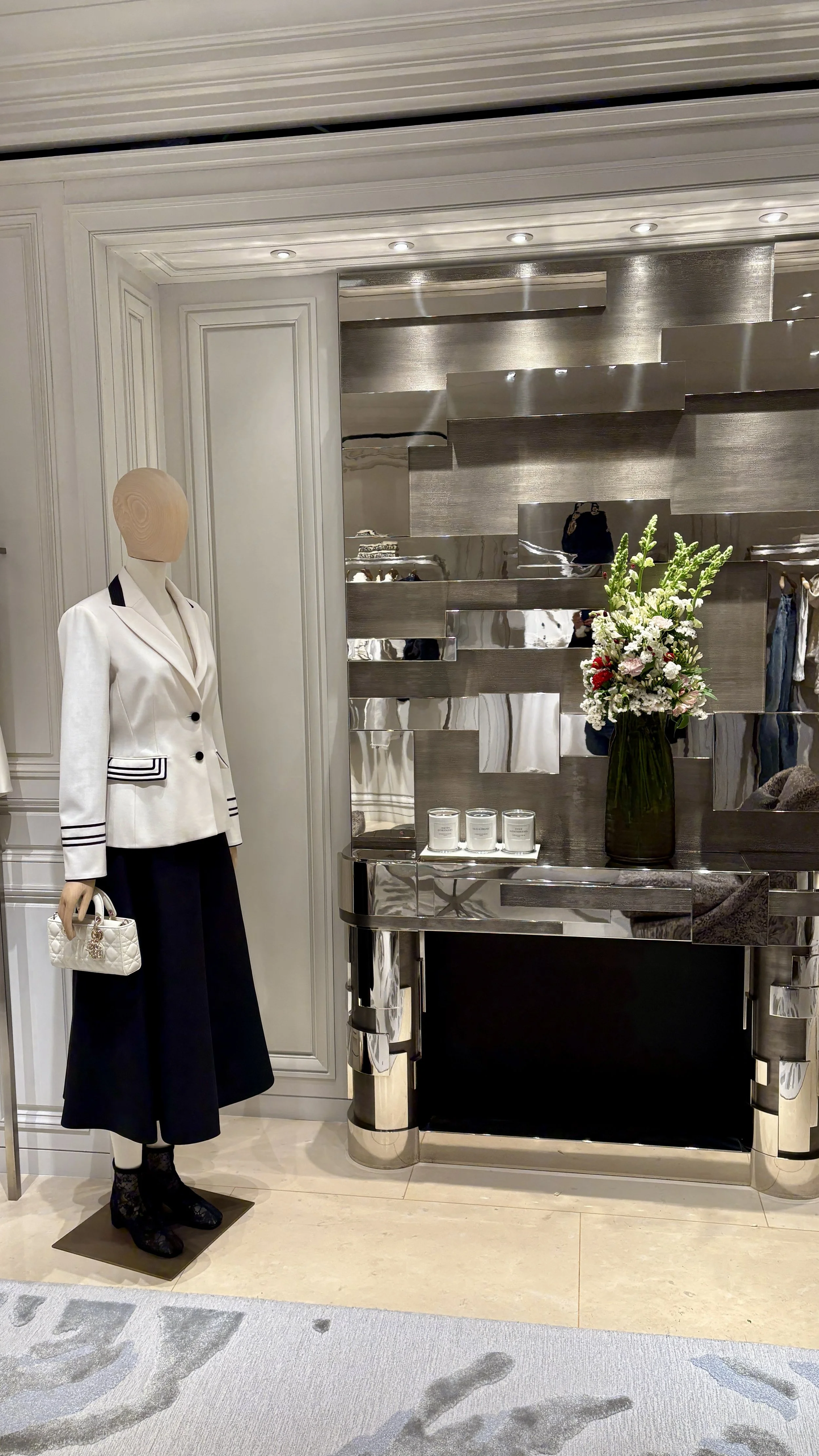 Sophisticated floral installation featuring seasonal flowers in a luxury boutique for the Spring Summer 2027 collection