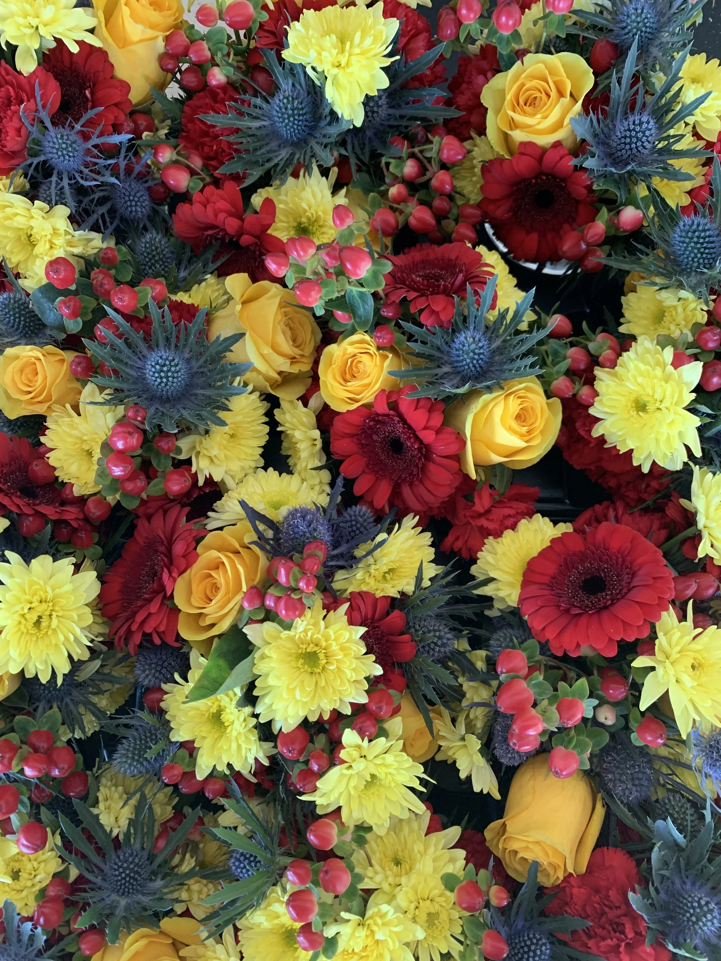 Vibrant floral composition by Mosaic Flowers inspired by the Lidl Trek cycling team, featuring bold red, yellow and blue blooms created for a luxury brand activation during the Tour de France Barcelona 2026