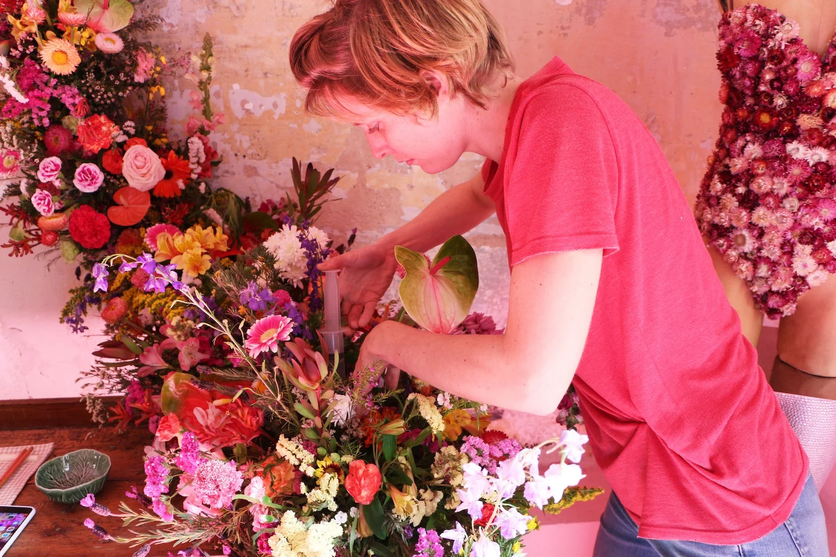 Floral artist Margaux watering fresh flower structure at Mosaic’s “The Floral Experience"
