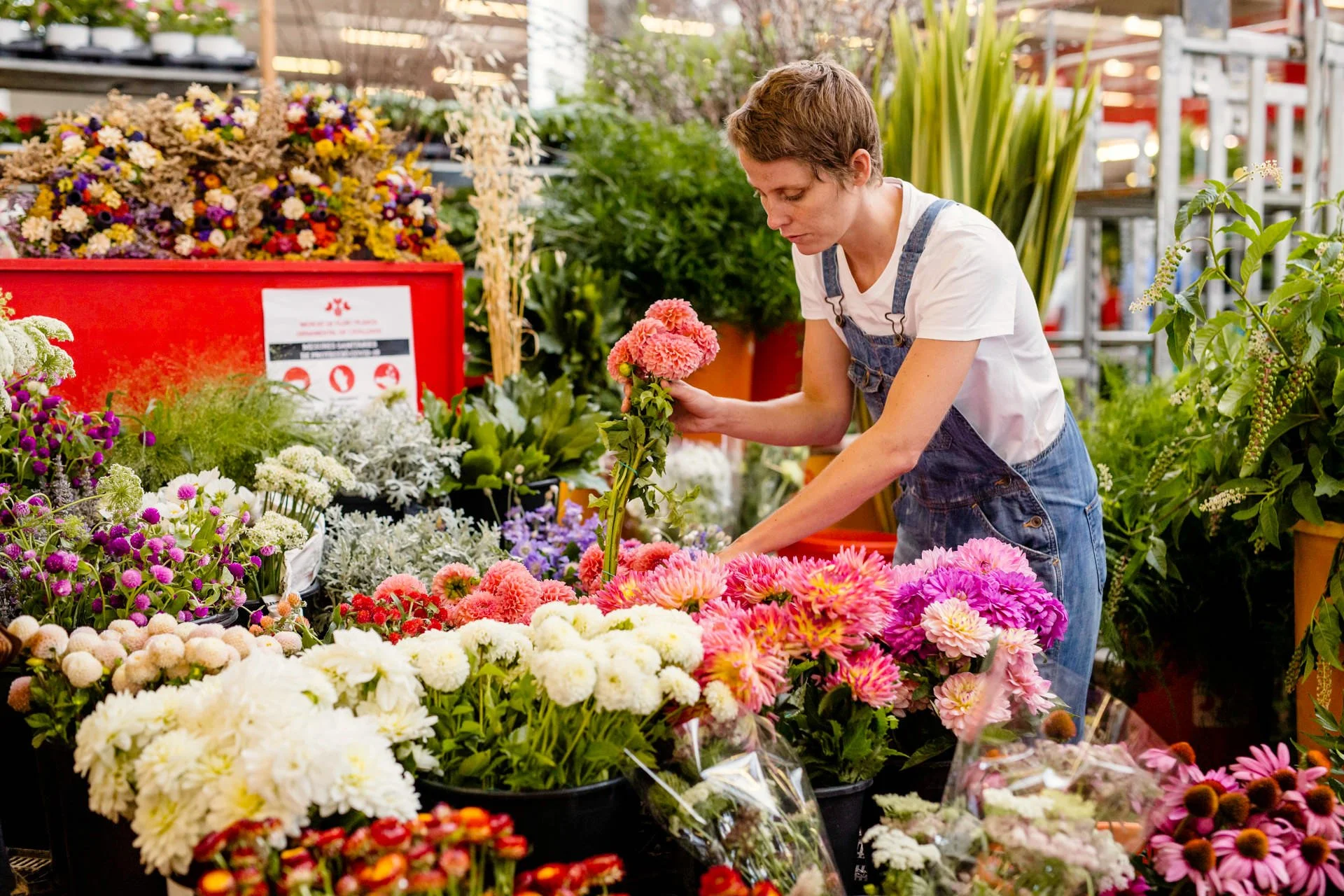 Floral designer Margaux Bastid selecting fresh blooms in the Barcelona flower market for destination events and luxury creations