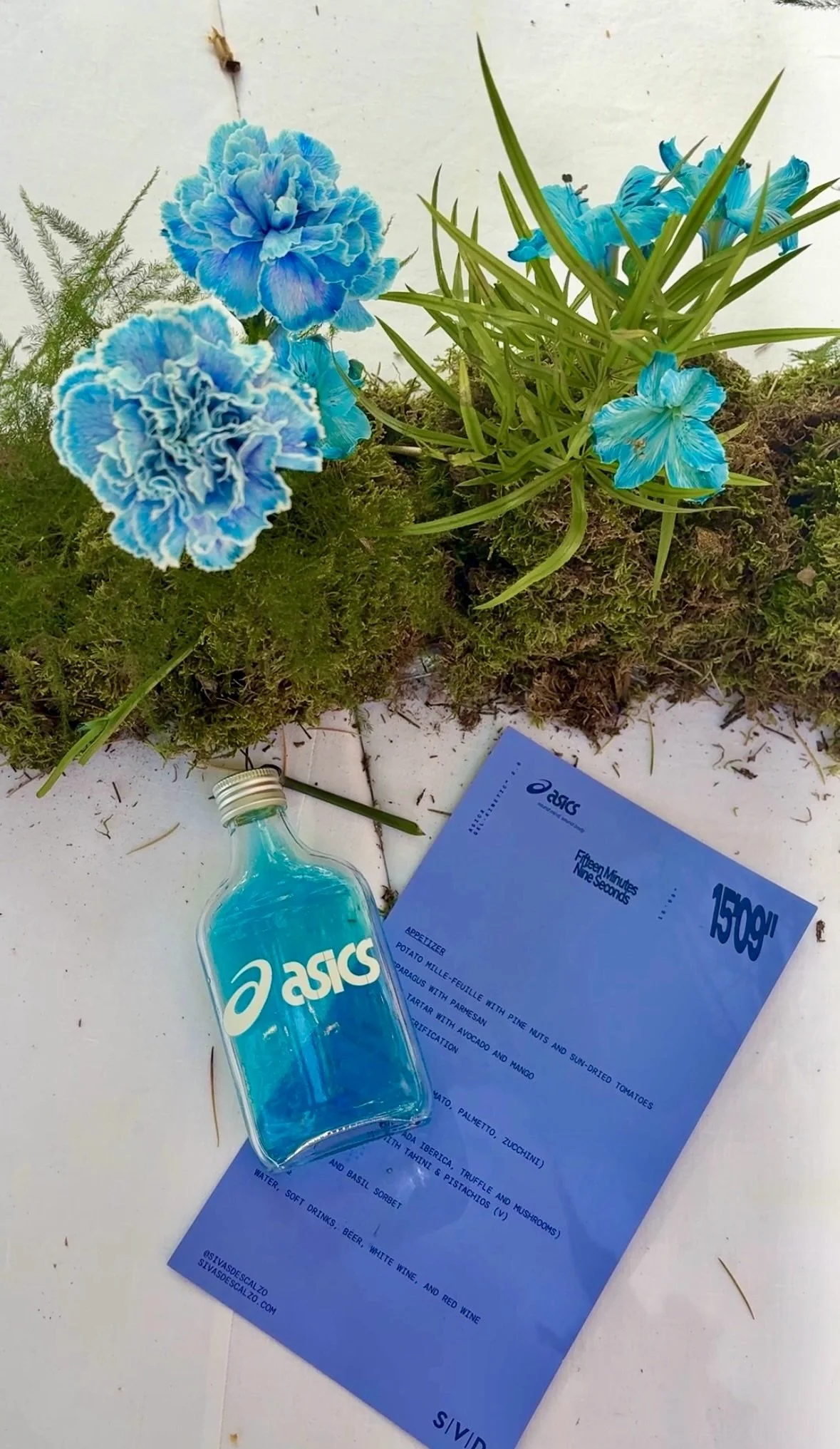 Refined table styling featuring the bespoke floral runner, blue botanical accents and ASICS event stationery, designed for a luxury brand event organized by Gabsfood near Barcelona