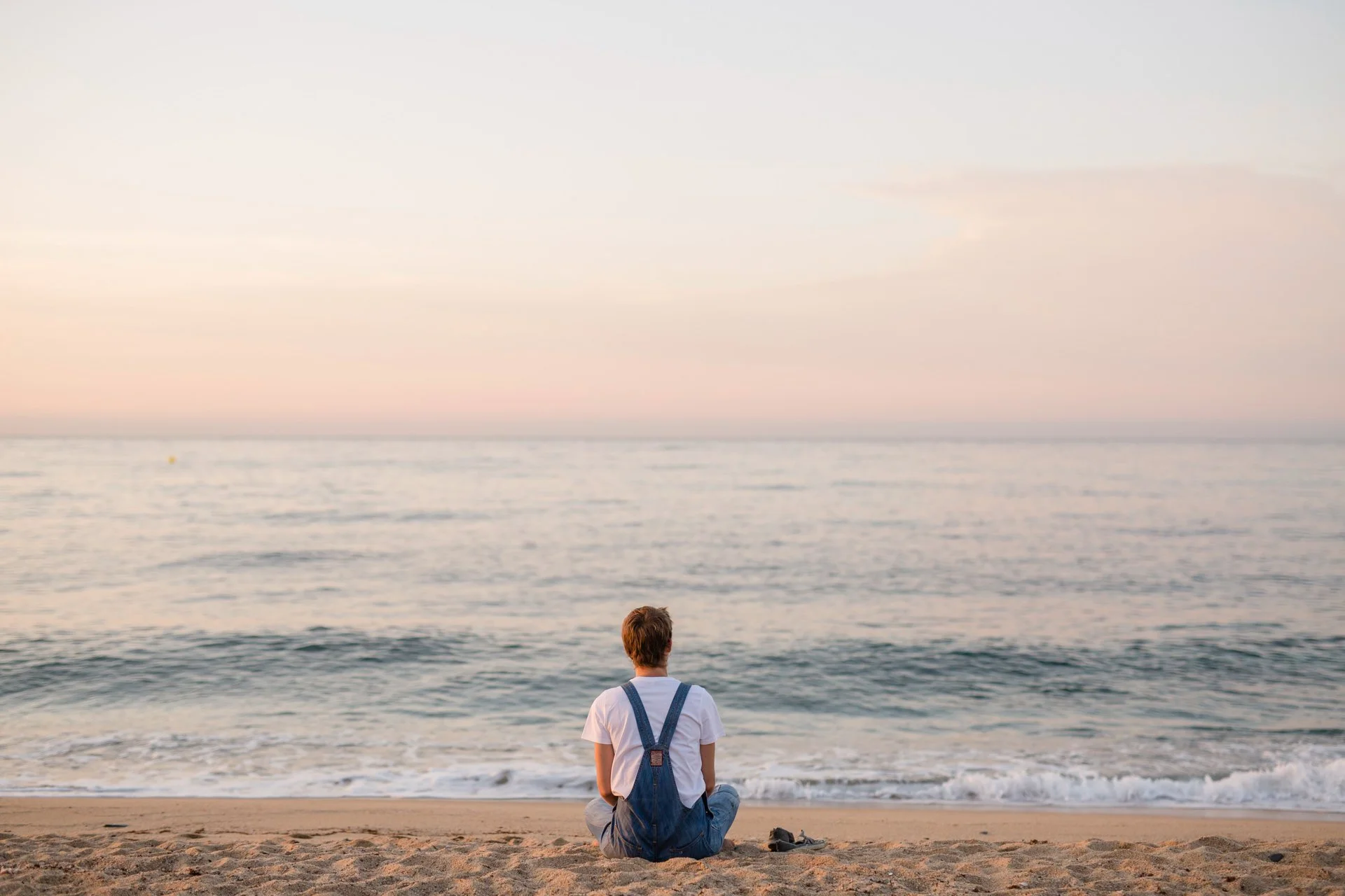 Floral artist Margaux Bastid meditating at sunrise on the beach in Barcelona, finding inspiration for international floral creations