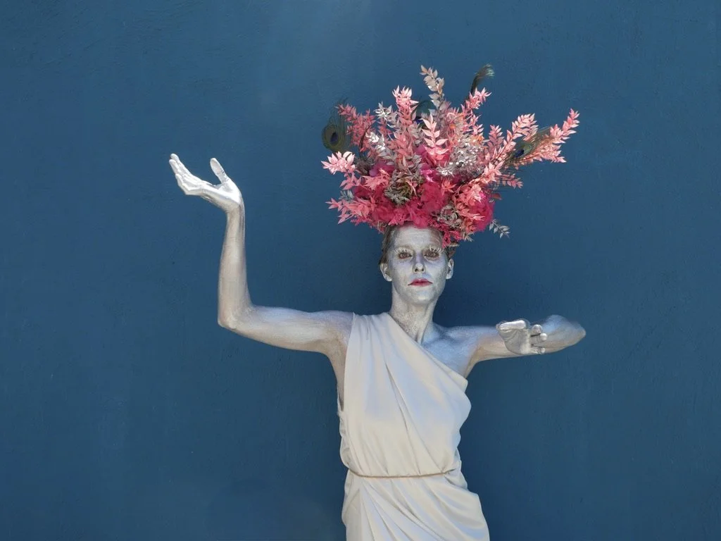 Cosmic goddess portrait with Margaux painted in silver, wearing a bold floral crown of fresh flowers.