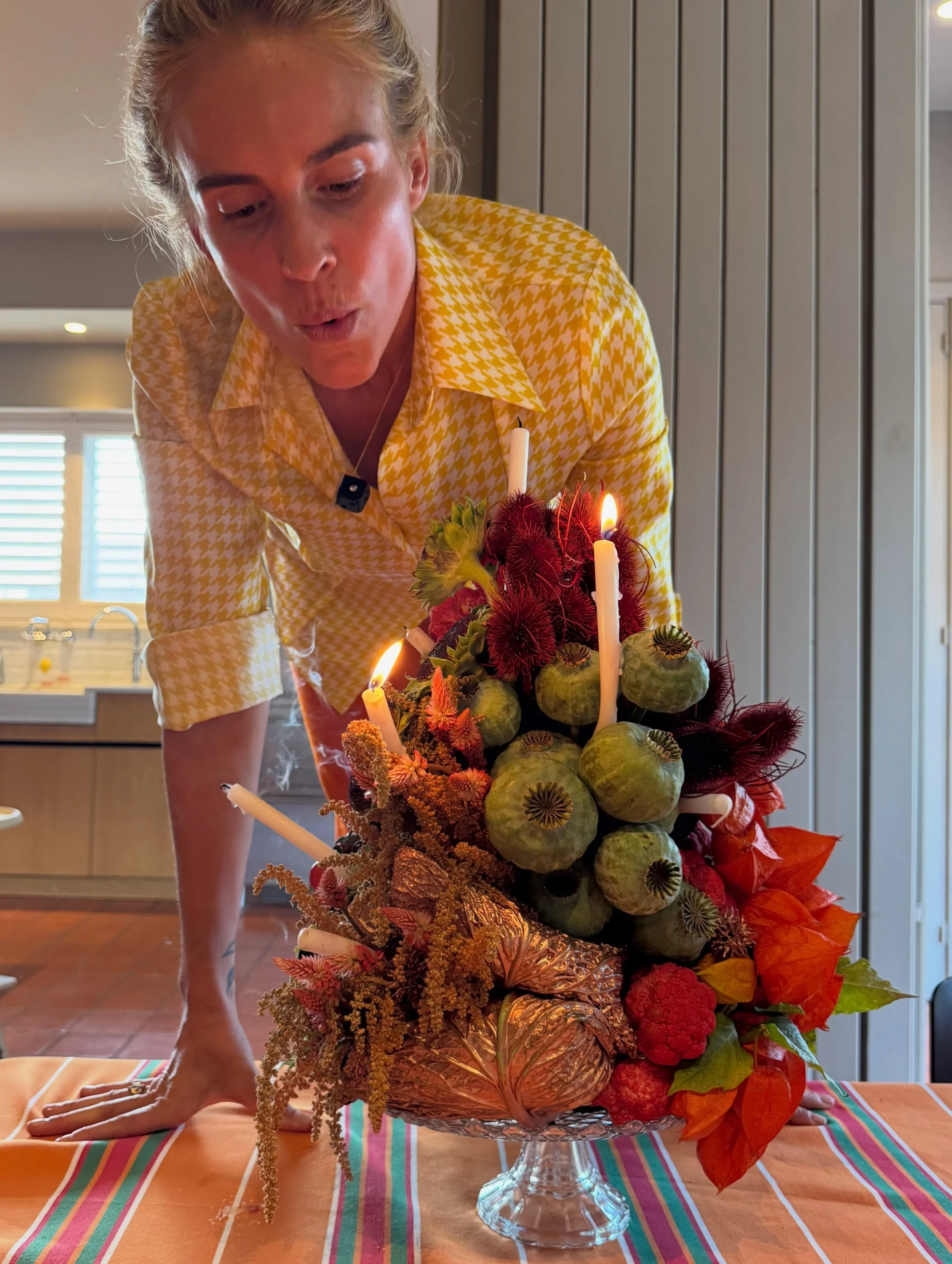 Bespoke floral sculpture created by Mosaic for Blanca Miró’s birthday, commissioned as a gift from LA VESTE and combining vibrant red and green botanicals with fruit, vegetables and candlelight