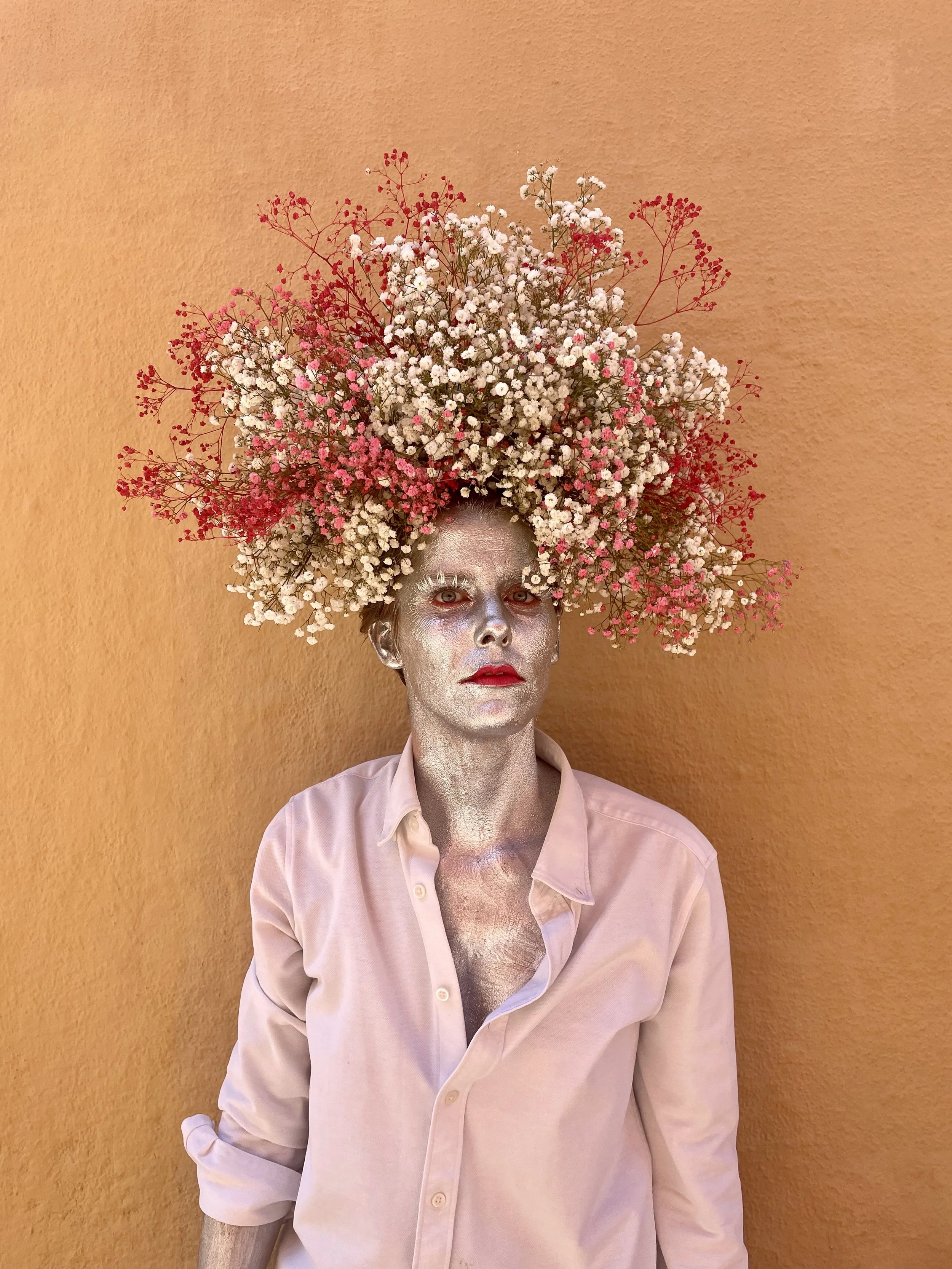 Floral artist Margaux wearing a crown of gypsophila flowers, painted in silver for an artistic portrait in Barcelona