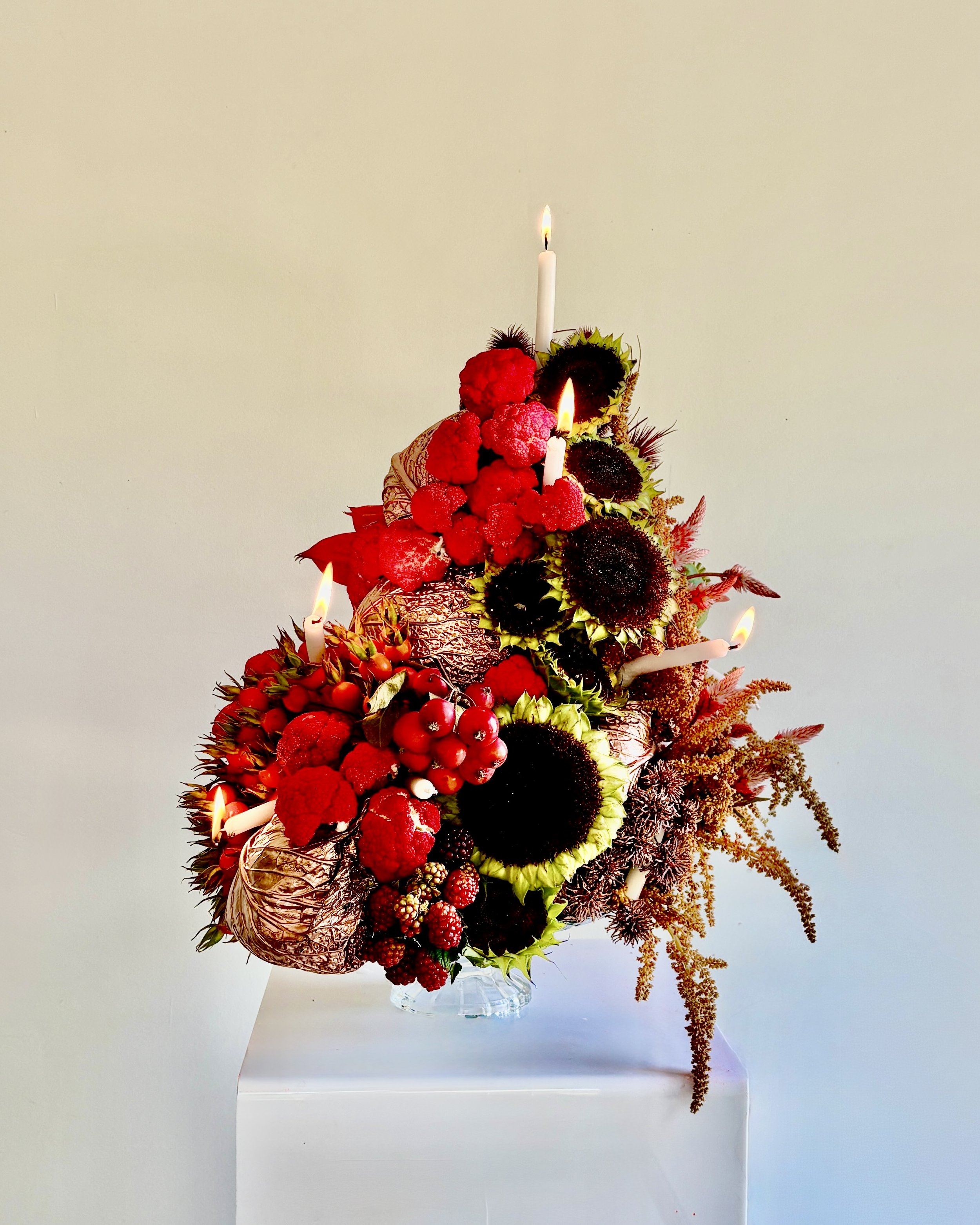 Unique floral birthday cake created by Mosaic as a gift from LA VESTE for designer Blanca Miró, combining flowers, plants, fruit, vegetables and candles in an expressive sculptural composition