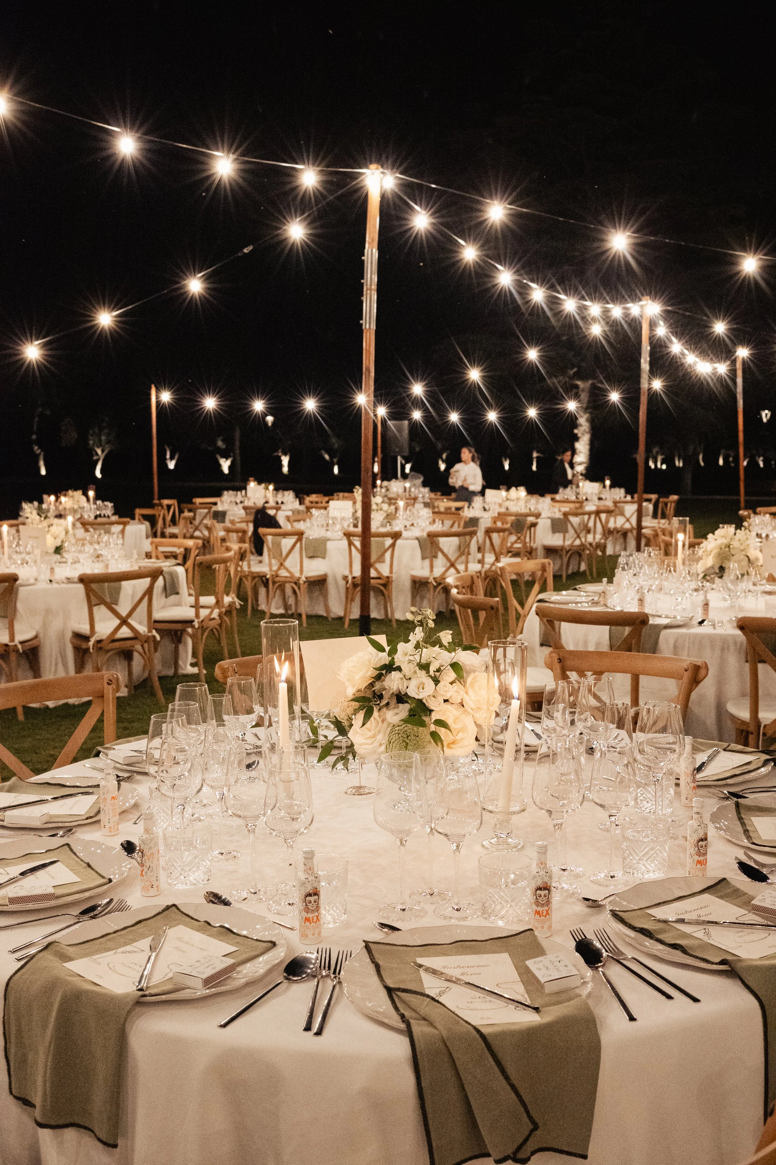 Luxury wedding table styling with delicate floral centerpieces and candlelight ambiance by Mosaic, crafted to elevate an outdoor evening reception