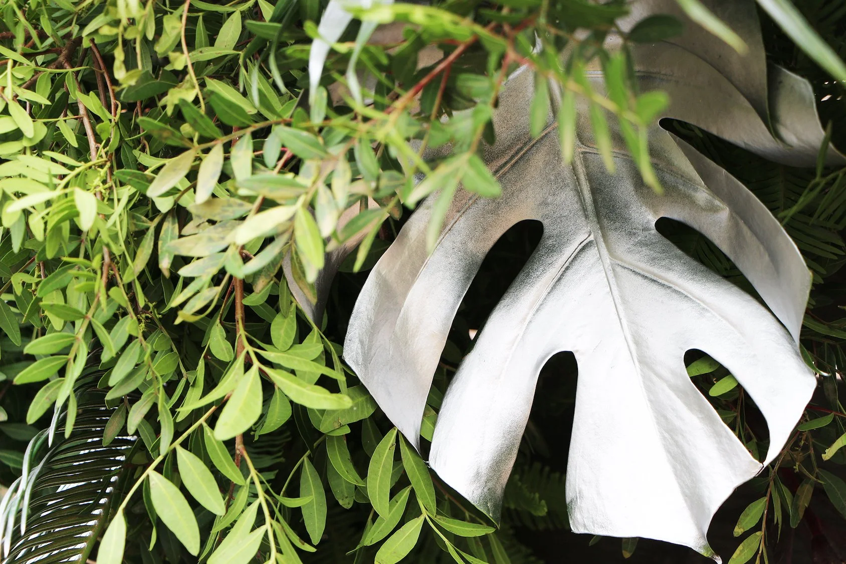 Close-up of hand-painted silver monstera leaf, part of Mosaic’s bespoke floral art installation for luxury events in Barcelona