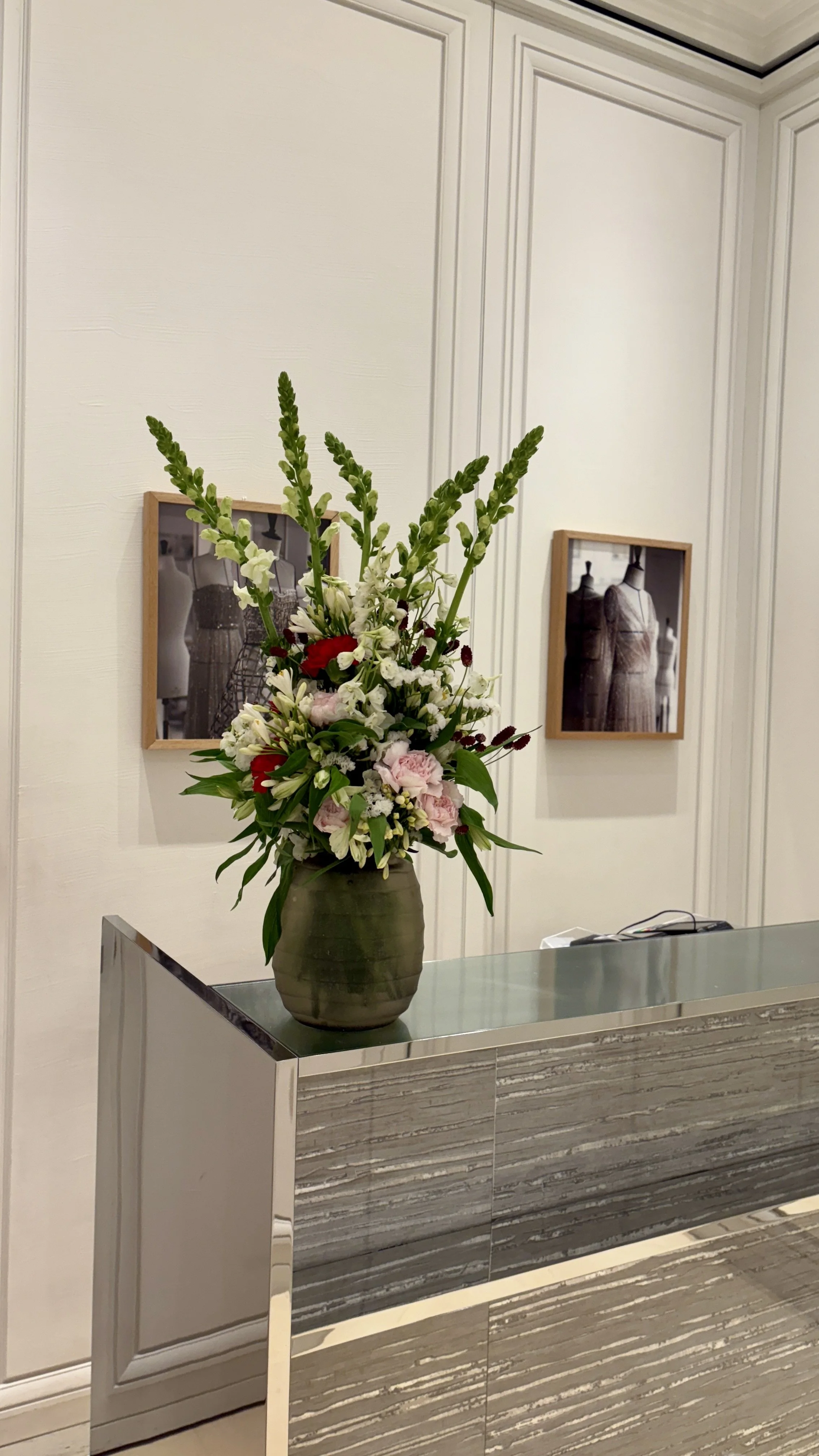Modern floral arrangement styled on a reception counter in a luxury boutique, reflecting contemporary elegance and attention to detail