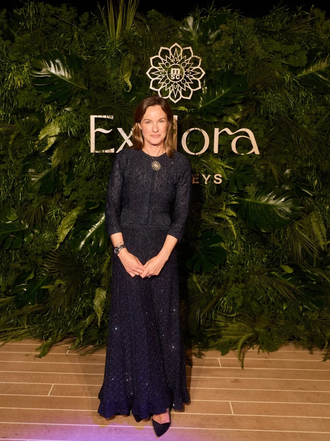Guest photographed in front of Mosaic's fresh foliage backdrop for Explora Journeys