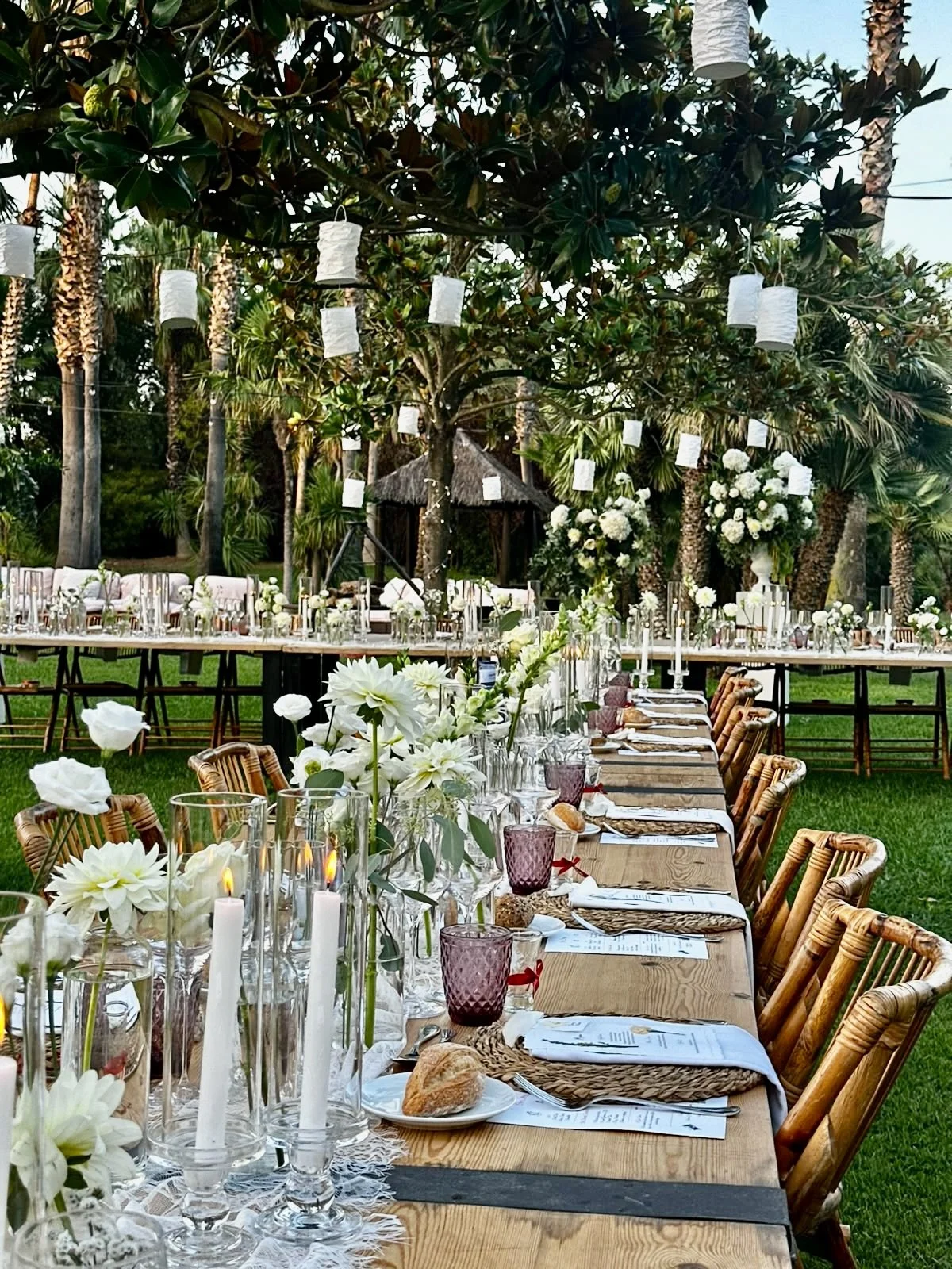 An atmospheric wedding reception designed by Mosaic for Megan and Shane, featuring lush floral details, hanging botanical elements, candlelit tables and an elegant outdoor setting at Cortal Gran