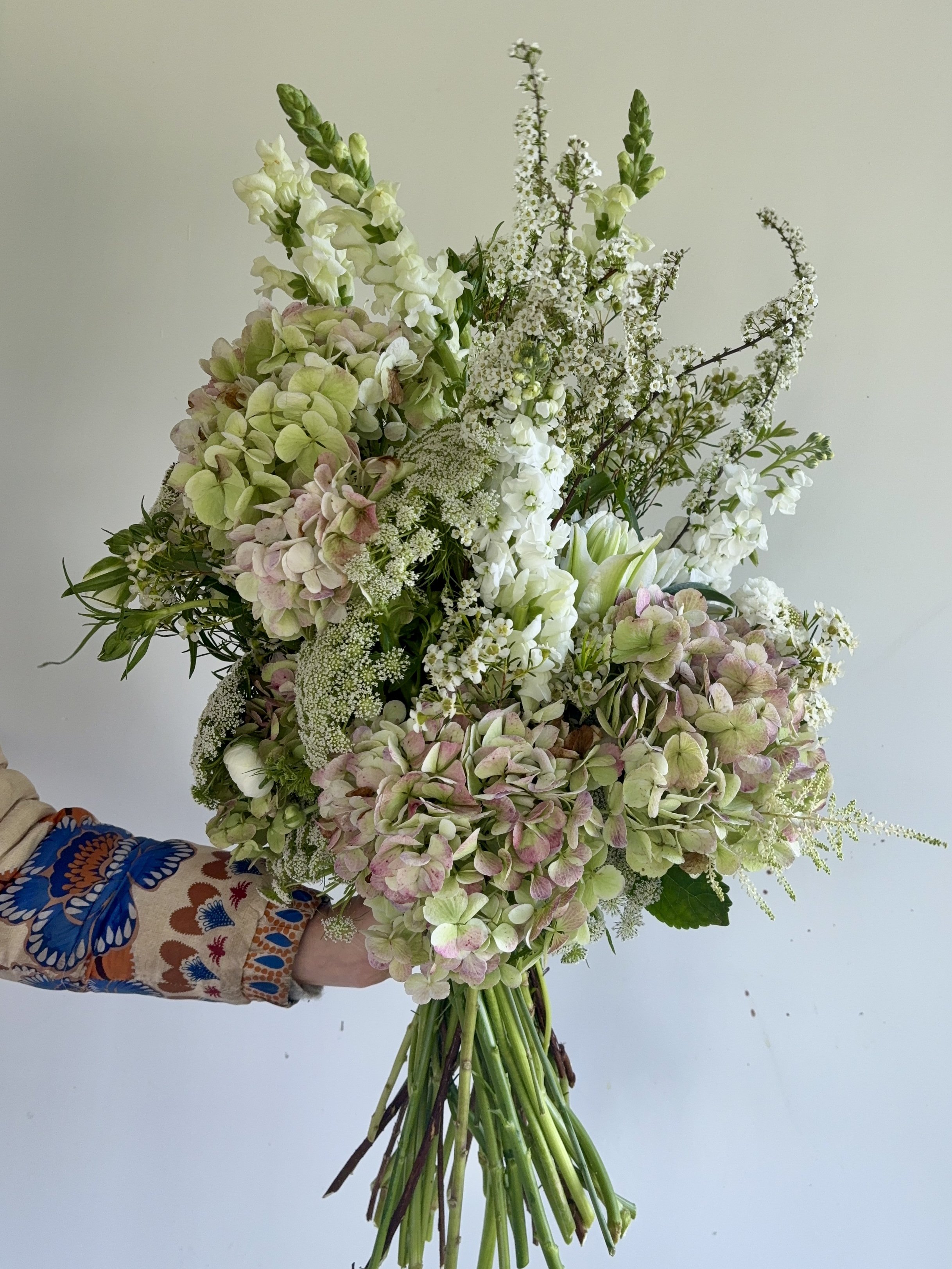 Luxury floral bouquet created for VIP gifting in Barcelona, featuring elegant white blooms, soft green hydrangeas, and seasonal flowers for an international luxury brand event