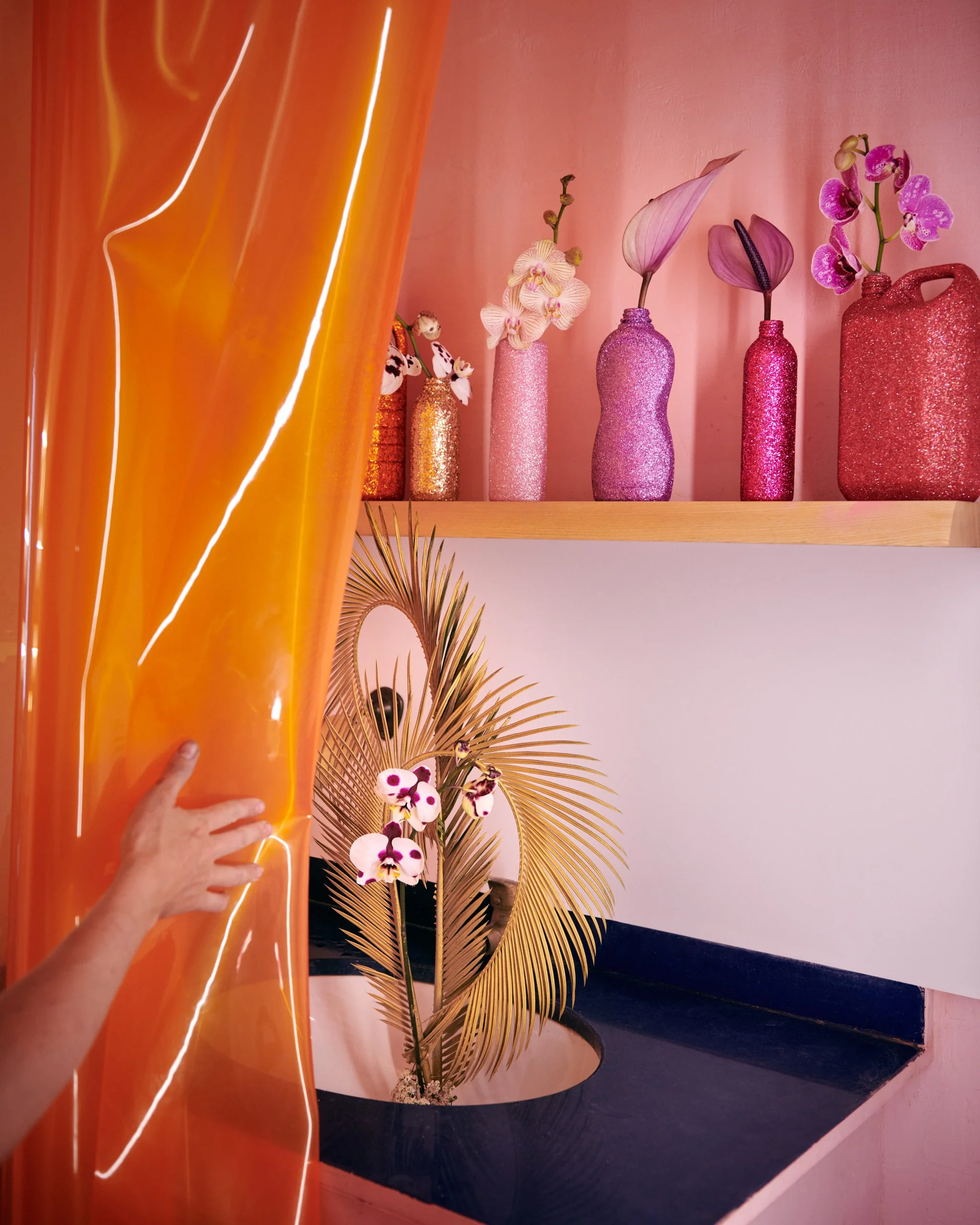 Ikebana-inspired installation with orchids and palm leaf, styled by Mosaic for The Bathroom exhibition in Barcelona