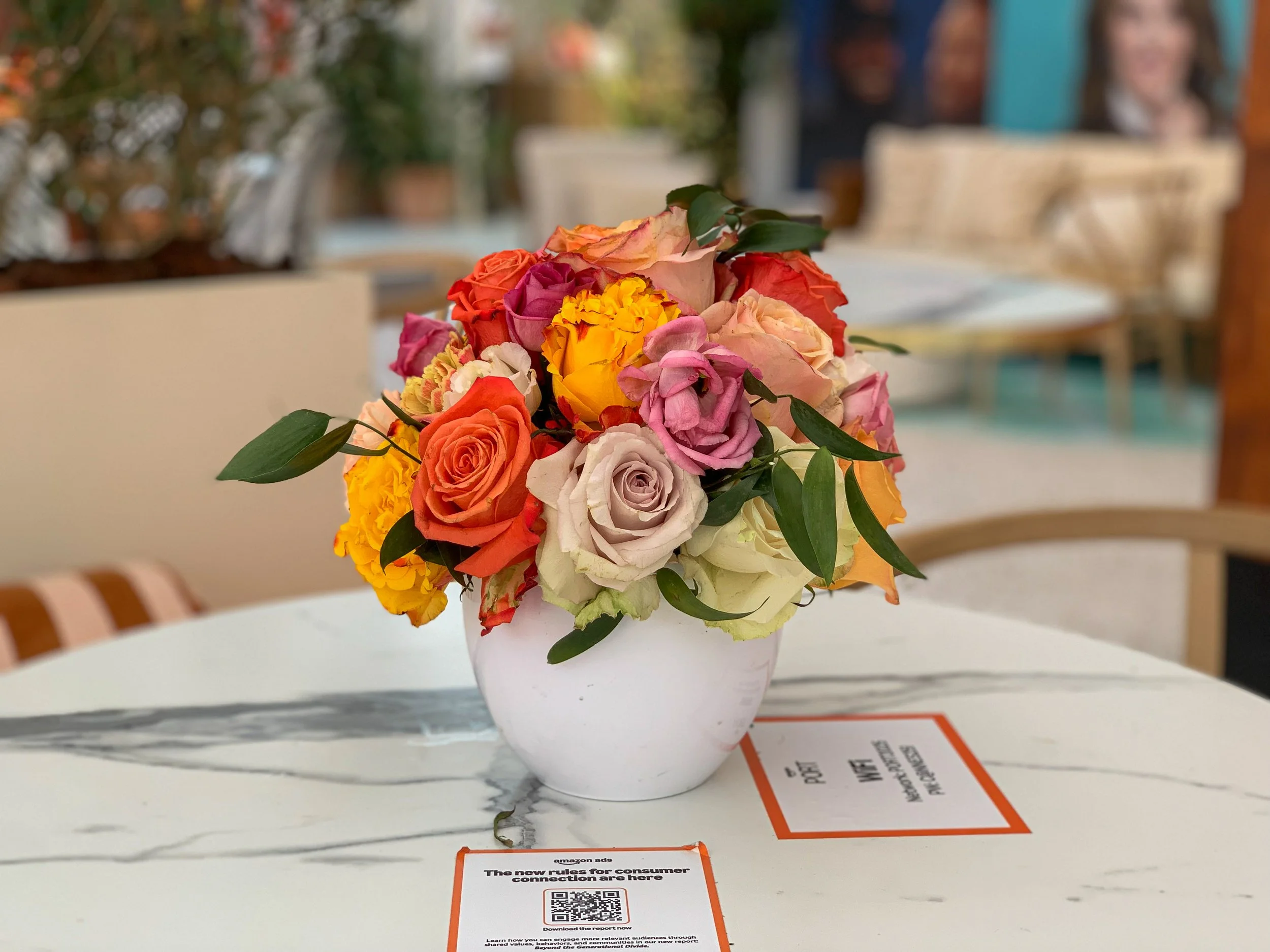 Luxury event flower bouquet by Mosaicflowers on café table for Amazon at Cannes Lions Festival 2025, featuring roses and peonies in bright seasonal tones