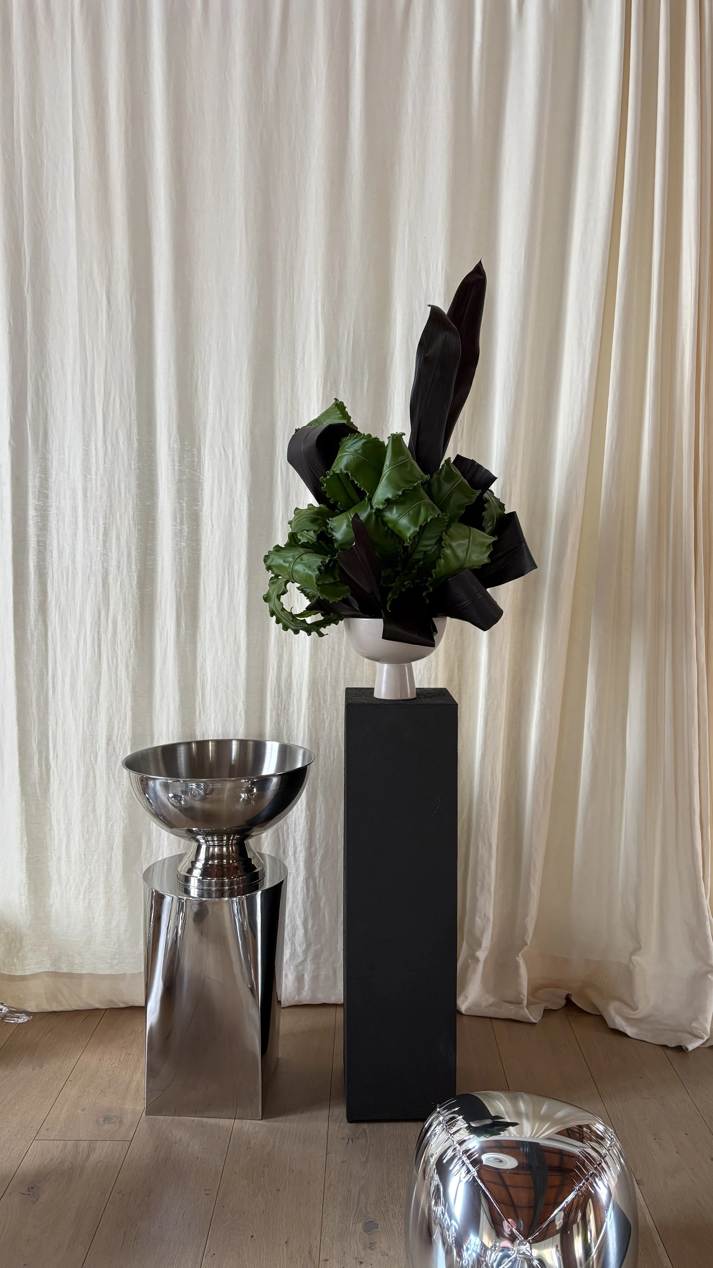 Sculptural floral composition crafted with black Cordyline leaves for the FAWE PR event, organized by A Point Agency at Juno House Barcelona, expressing modern luxury through bold botanical design