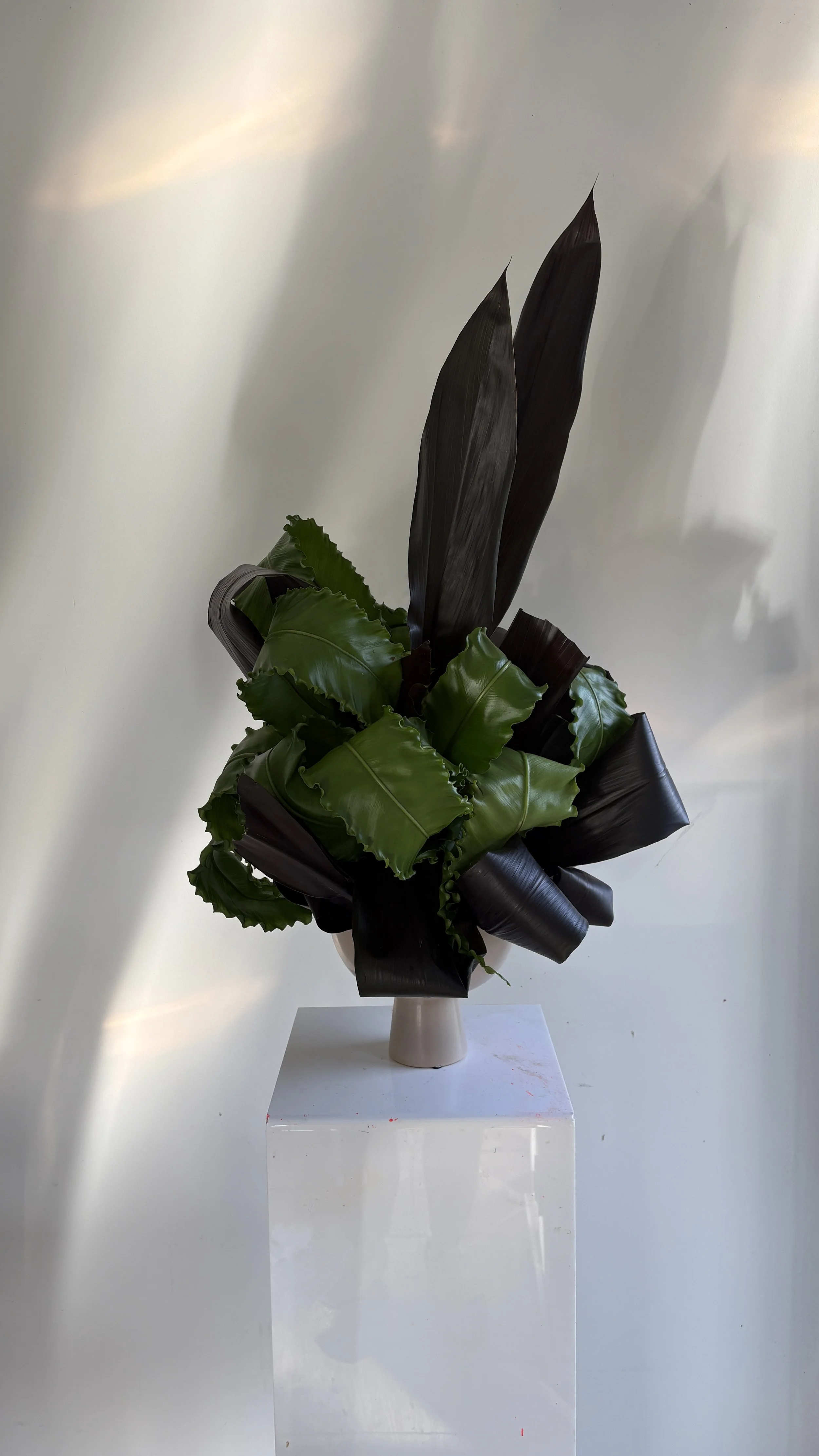 Artistic sculptural arrangement with black Cordyline leaves and textured botanical elements, designed for the FAWE PR event organized by A Point Agency at Juno House Barcelona