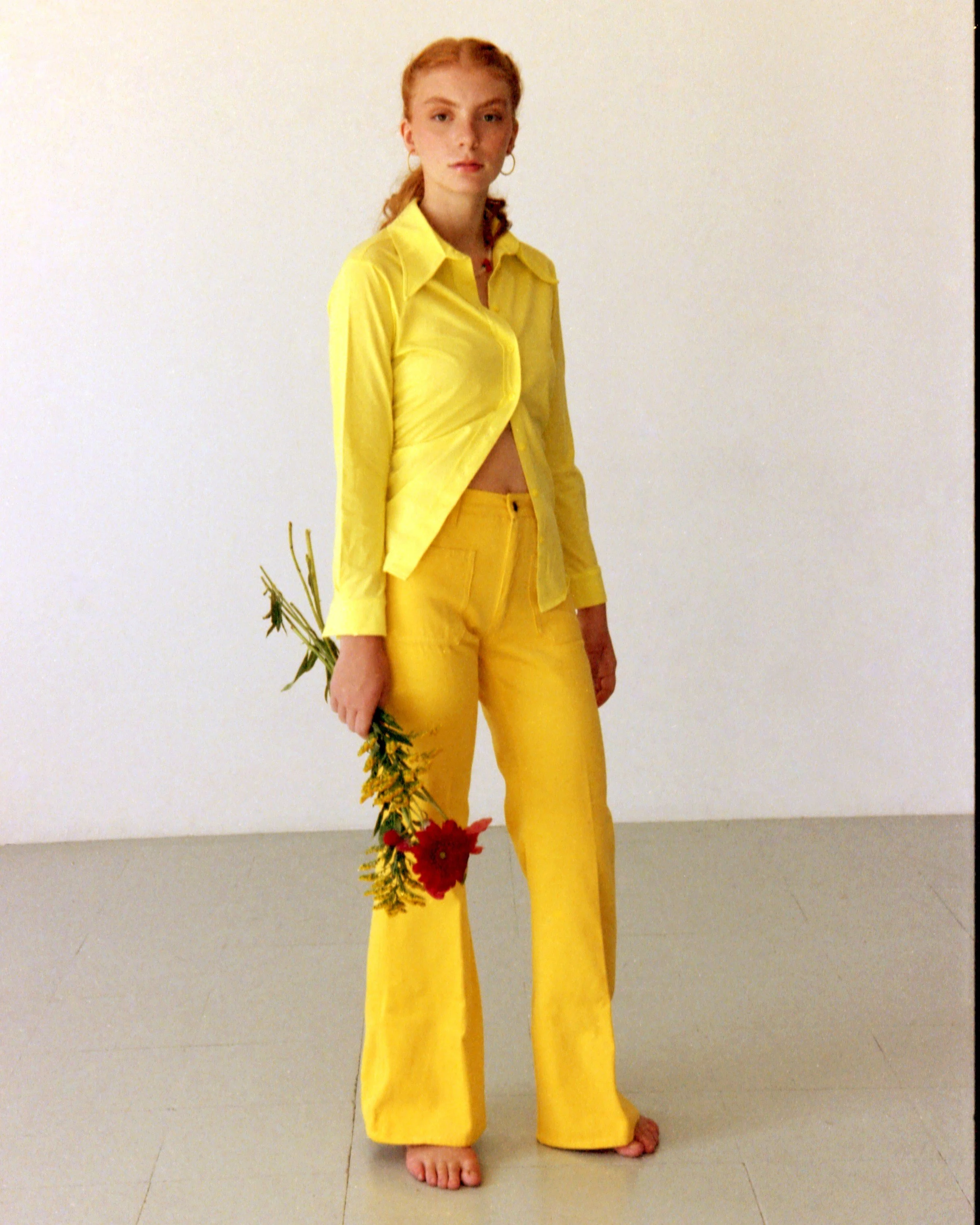 Woman in a yellow suit posing with flowers for a Mosaic editorial fashion and floral photoshoot in Barcelona