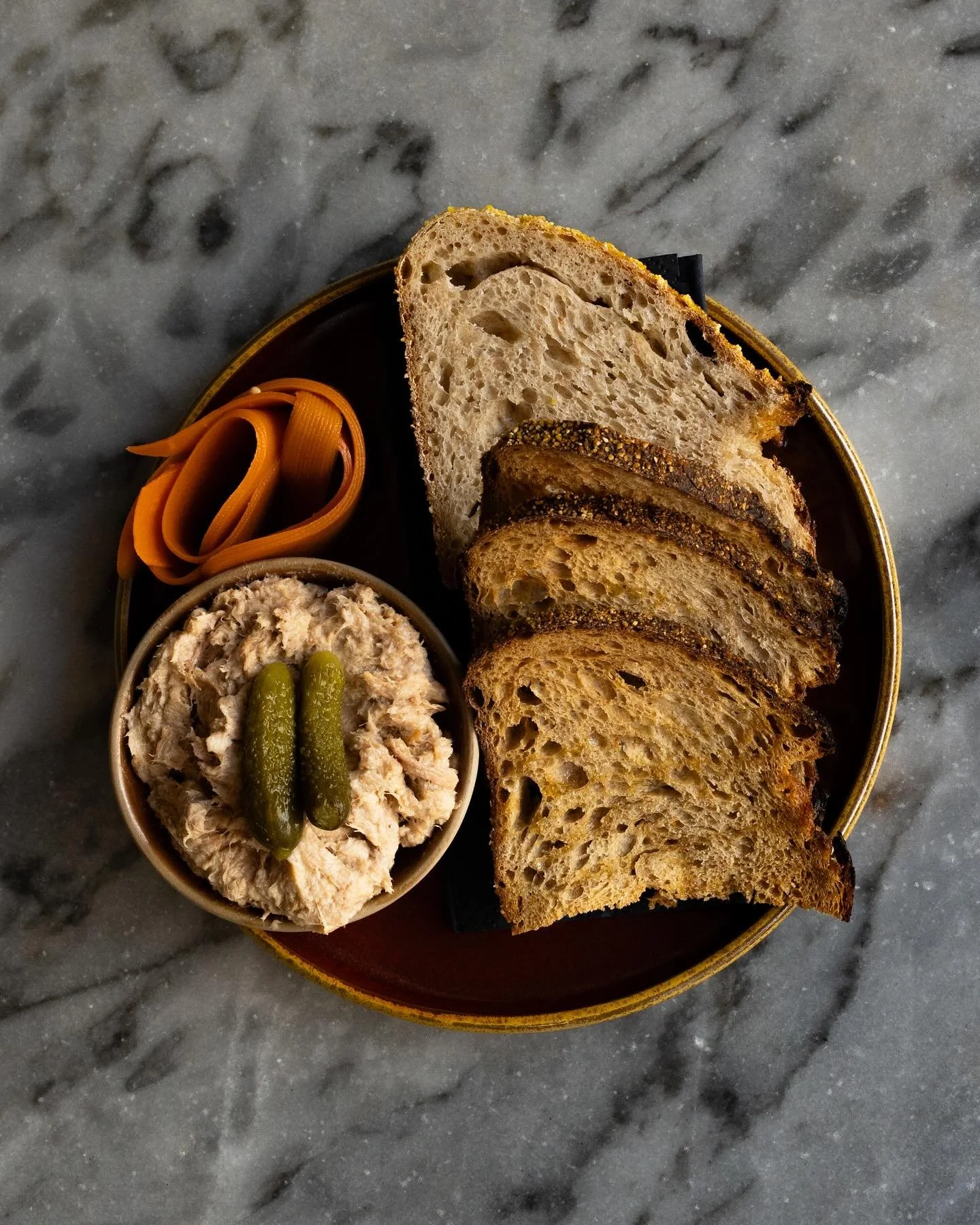 New item on the menu! 
Pork Rillettes de Berc&eacute; from Loire, France, are here to satiate your hunger! 

Served with homemade carrot and dill pickles, cornichons &amp; sourdough bread and crackers.

Get them while they last!