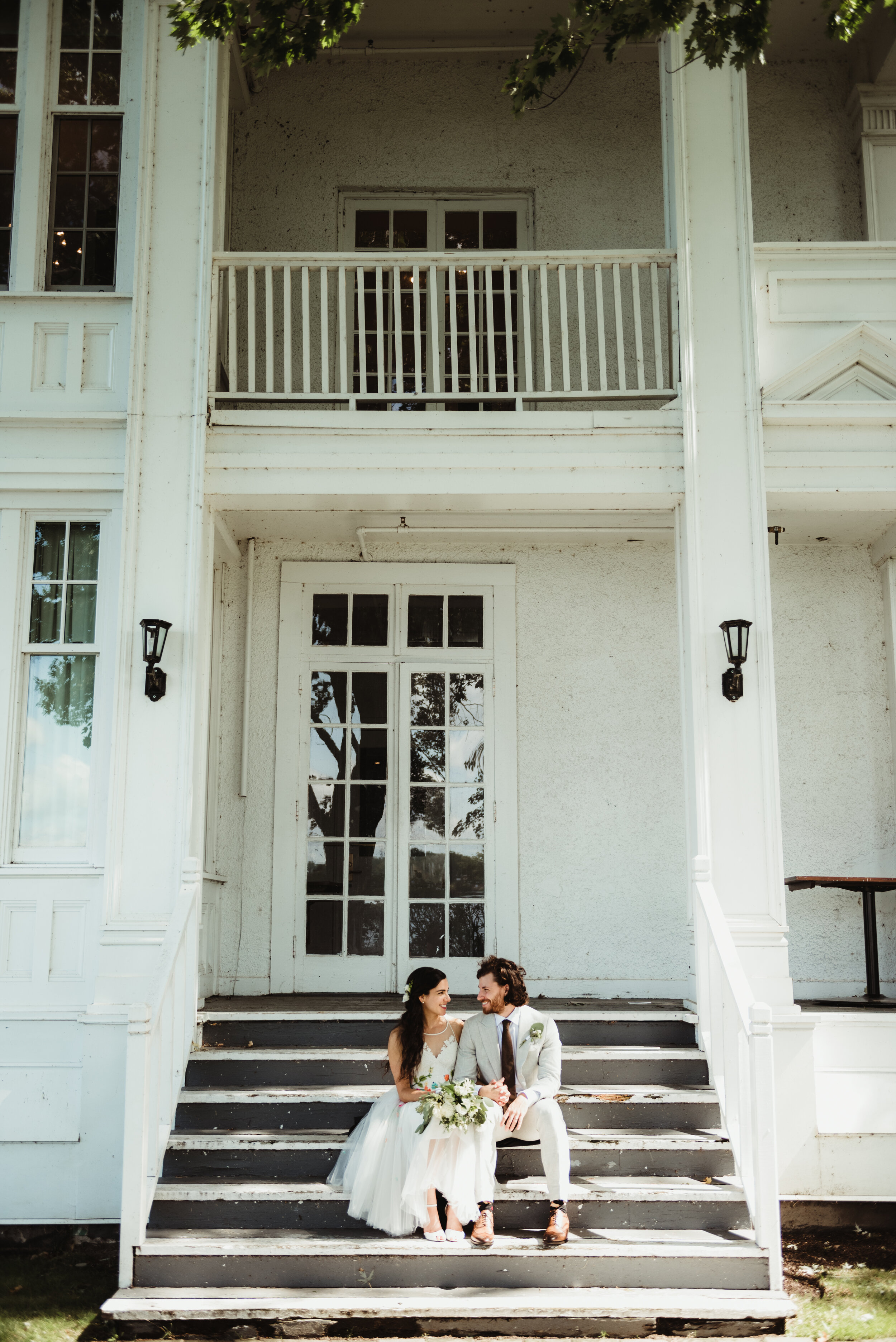 Bride and groom on steps of country house