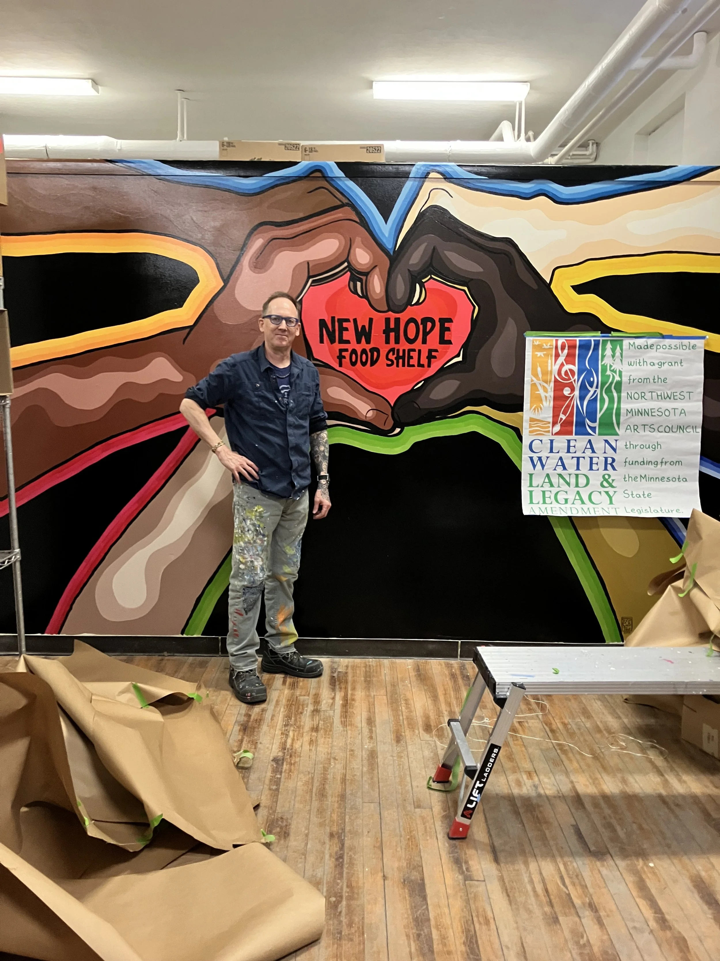 Trey in front of a mural he created