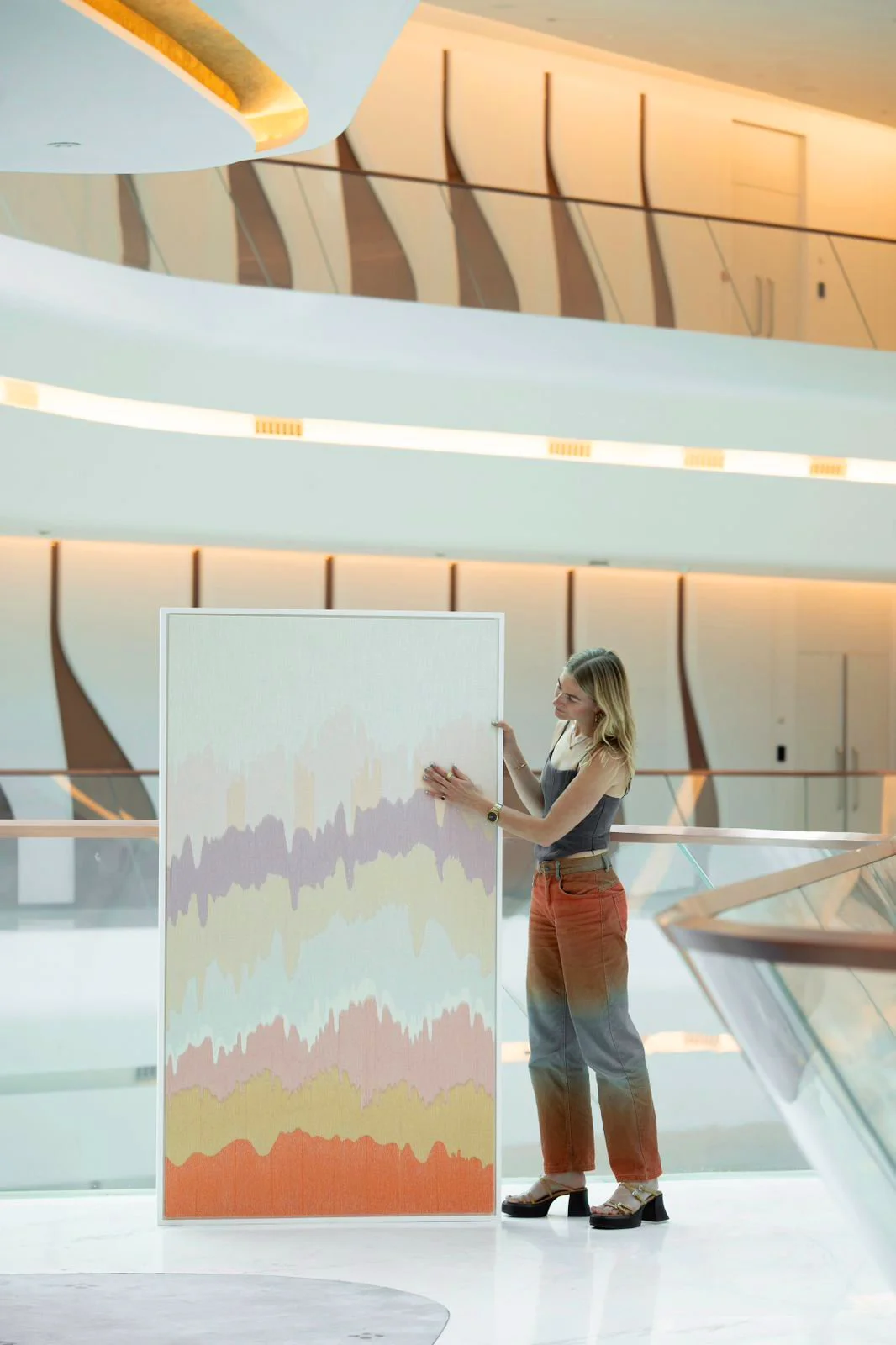 A women touching a colorful abstract display or textile artwork in hotel by Femm Amsterdam