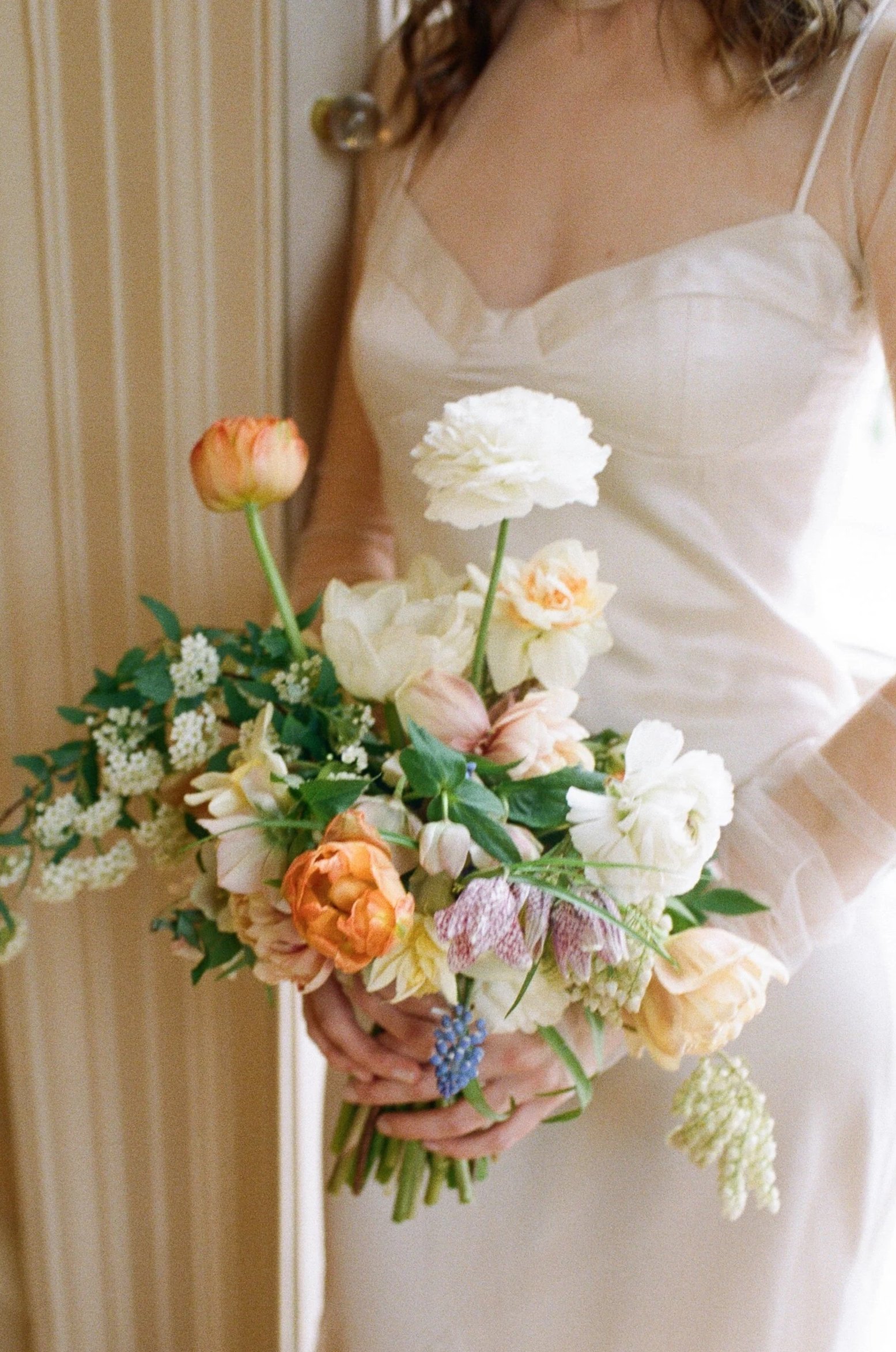 A woman in a wedding dress holding a bouquet of flowers.