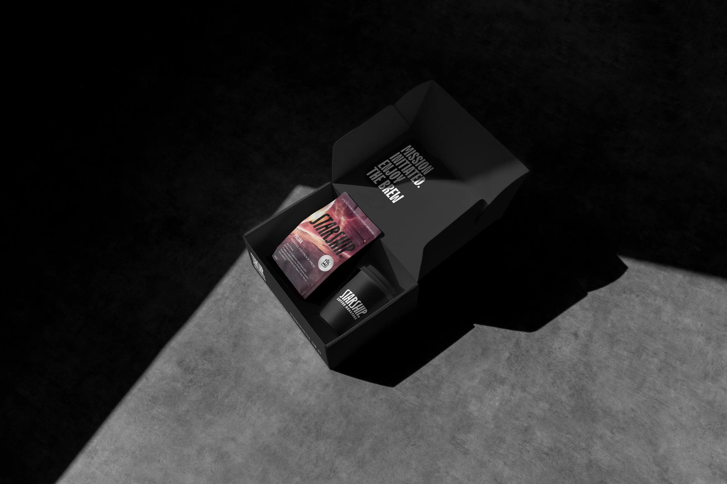 A black box with motivational text contains a card and a container, placed on a surface with contrasting light and dark shadows.