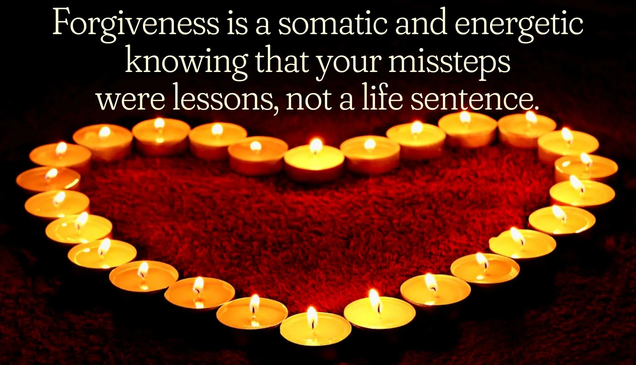 A heart-shaped arrangement of lit tea candles on a dark surface with an inspirational quote about forgiveness and learning from mistakes.