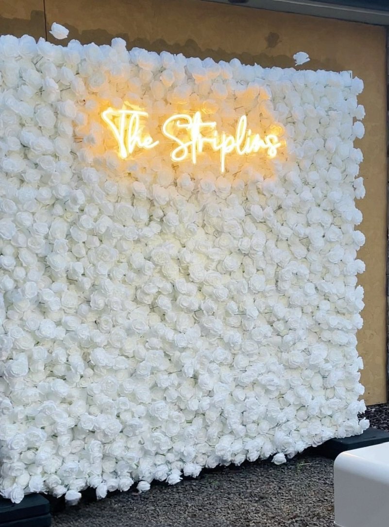 A white rose flower wall backdrop photographed at a wedding reception at Chateau de Harpe in West Linn, Oregon.