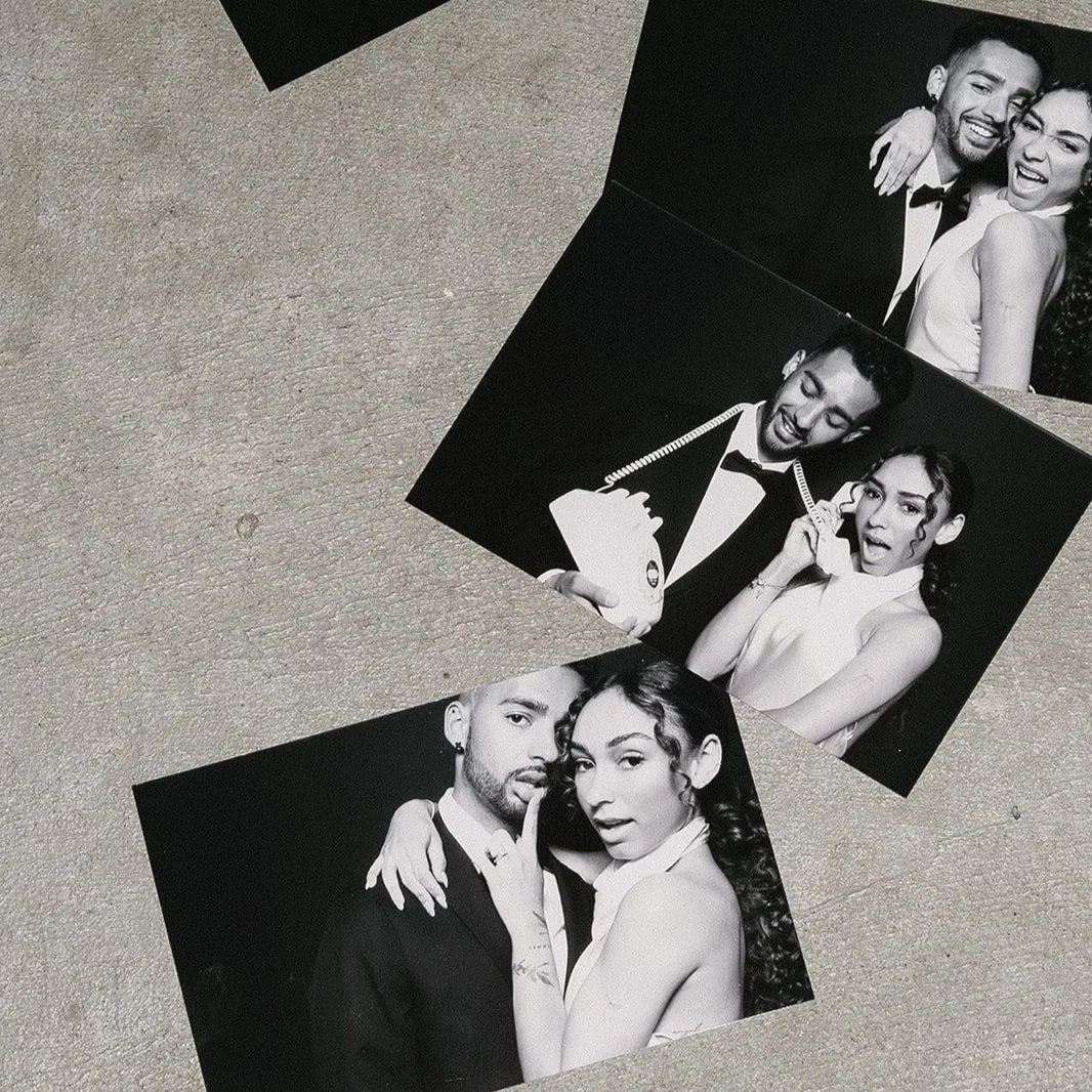 A handful of full size 4x6 photographs of a couple lay on a concrete floor at a Portland, OR wedding reception.