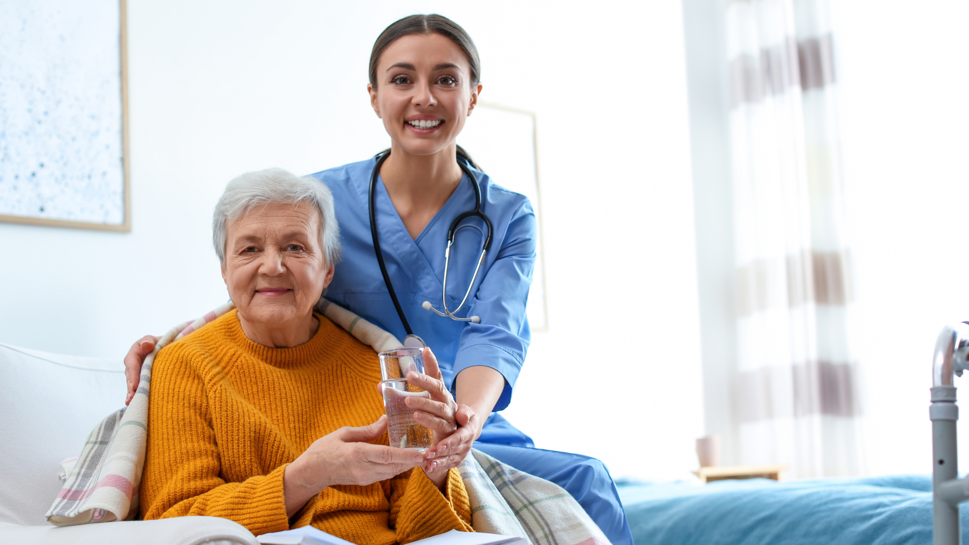 Care Worker Giving Water to Elderly Woman