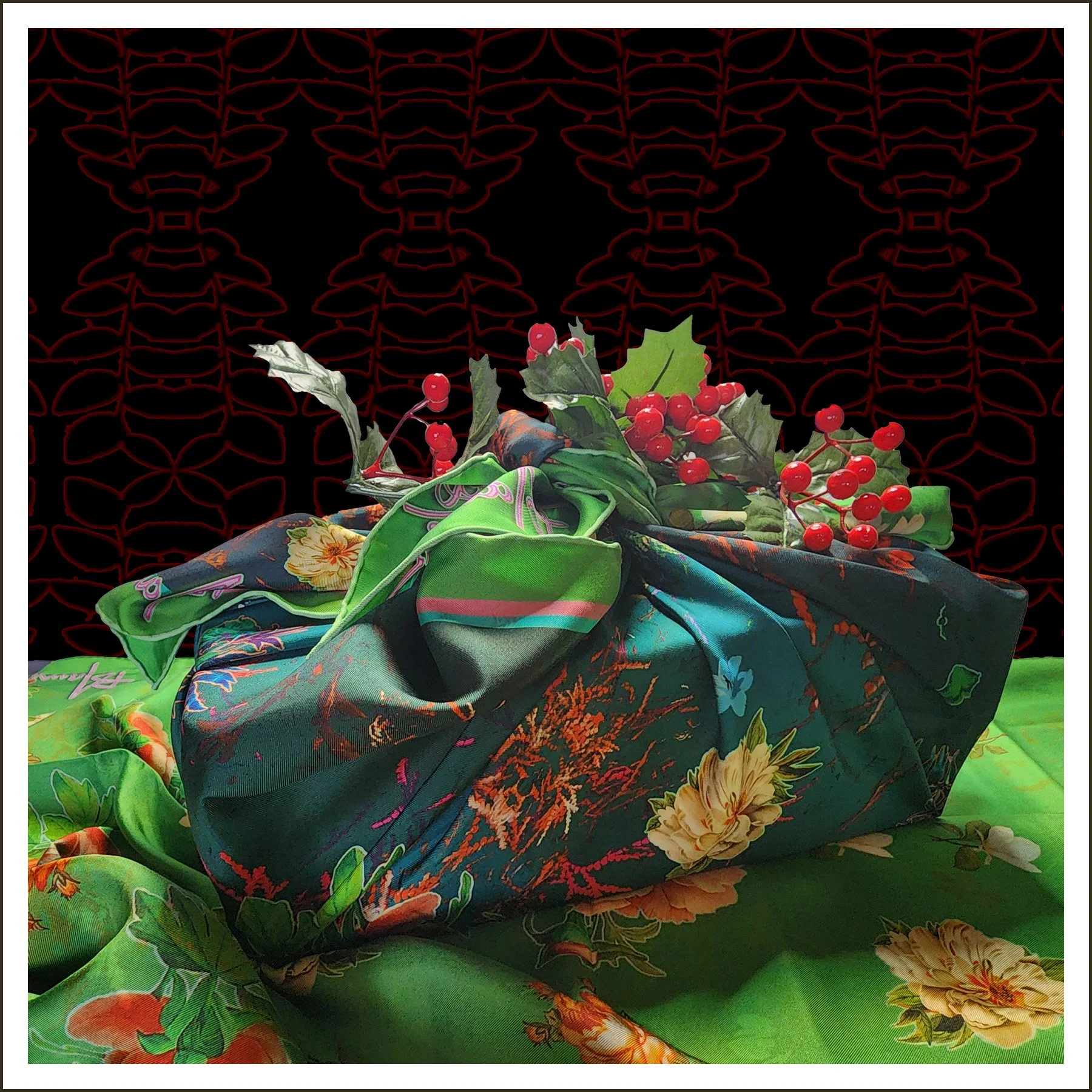 Decorative arrangement with green and black fabric, red berries, and holly leaves on a green cloth with a black and red patterned background.