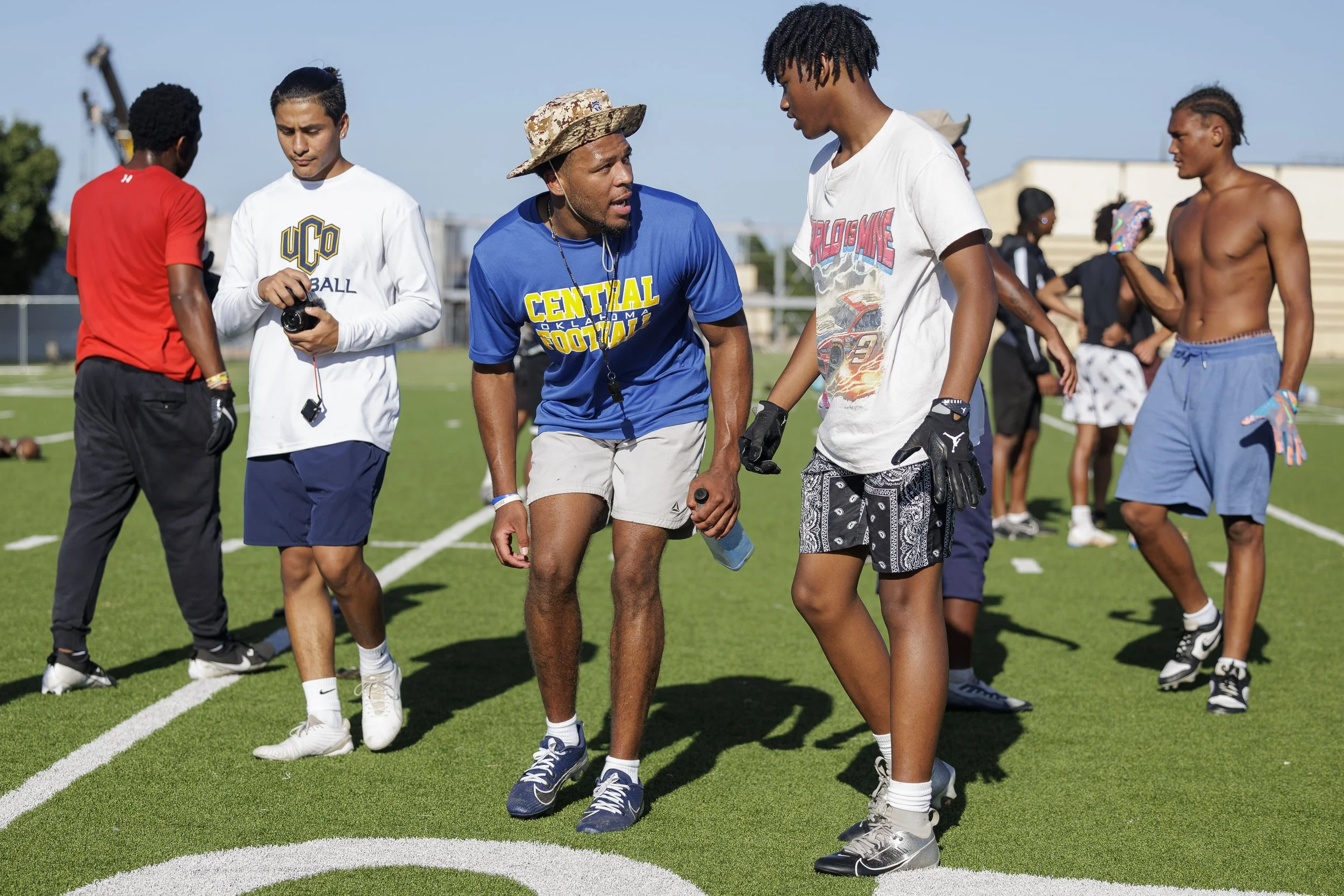 coach talking to athlete during football camp in summer