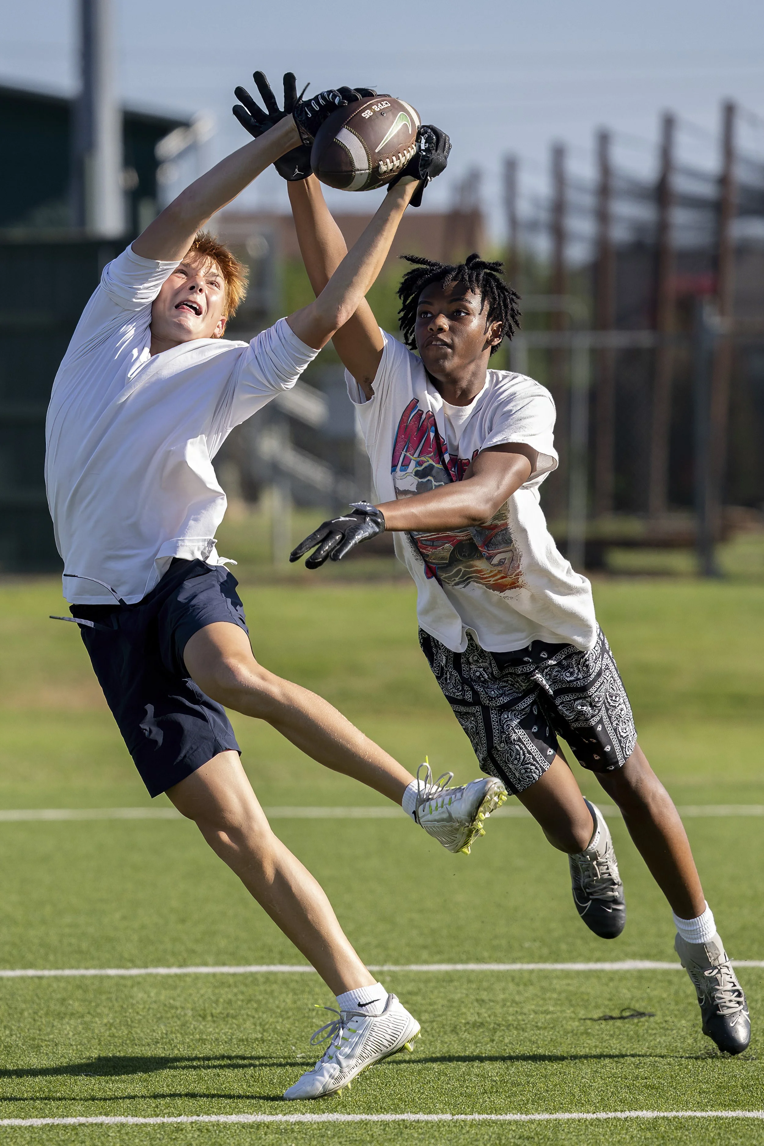 high school football athletes training in the summer sun
