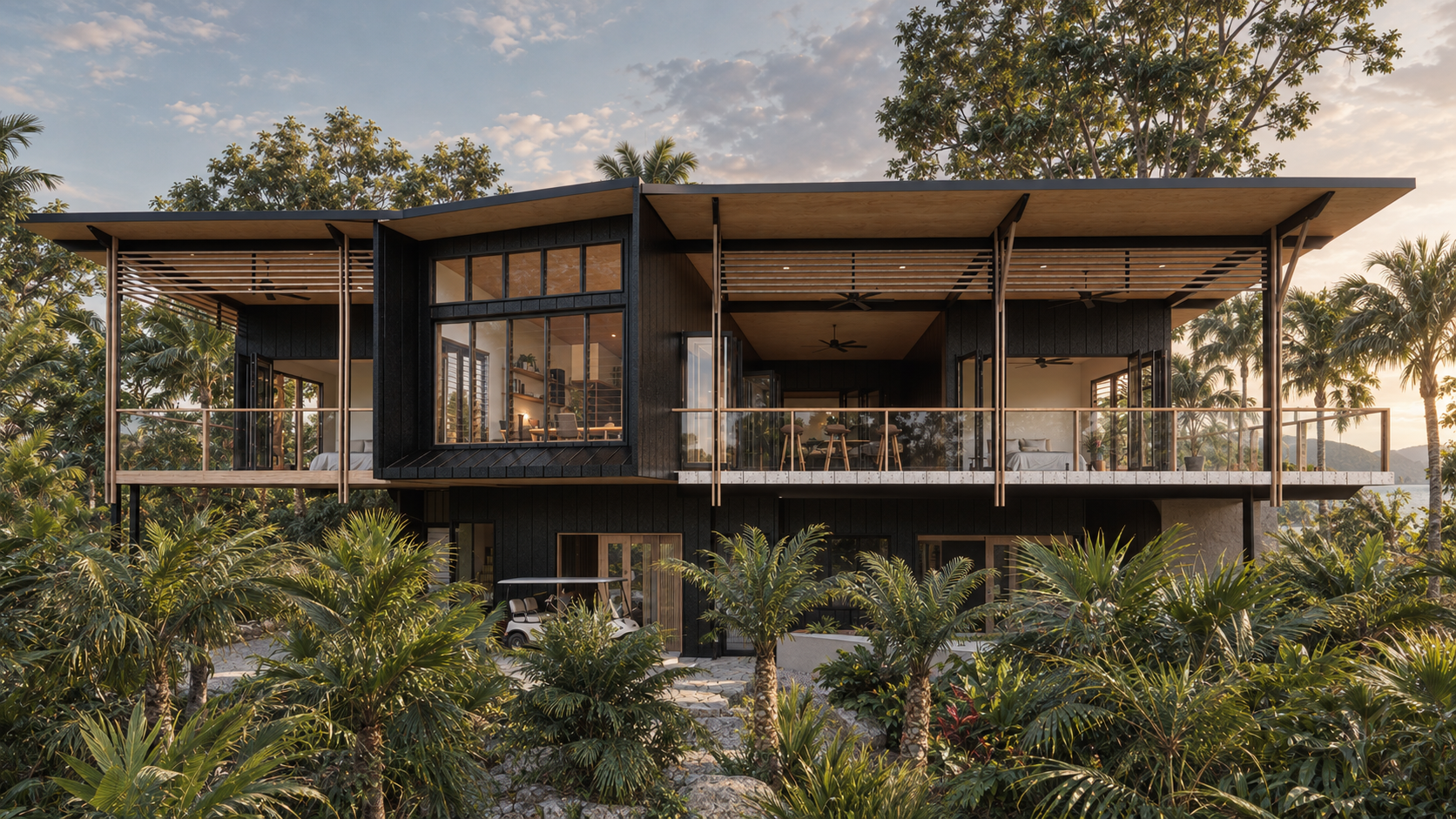 Modern two-story house surrounded by lush tropical vegetation, with large glass windows and an expansive balcony.