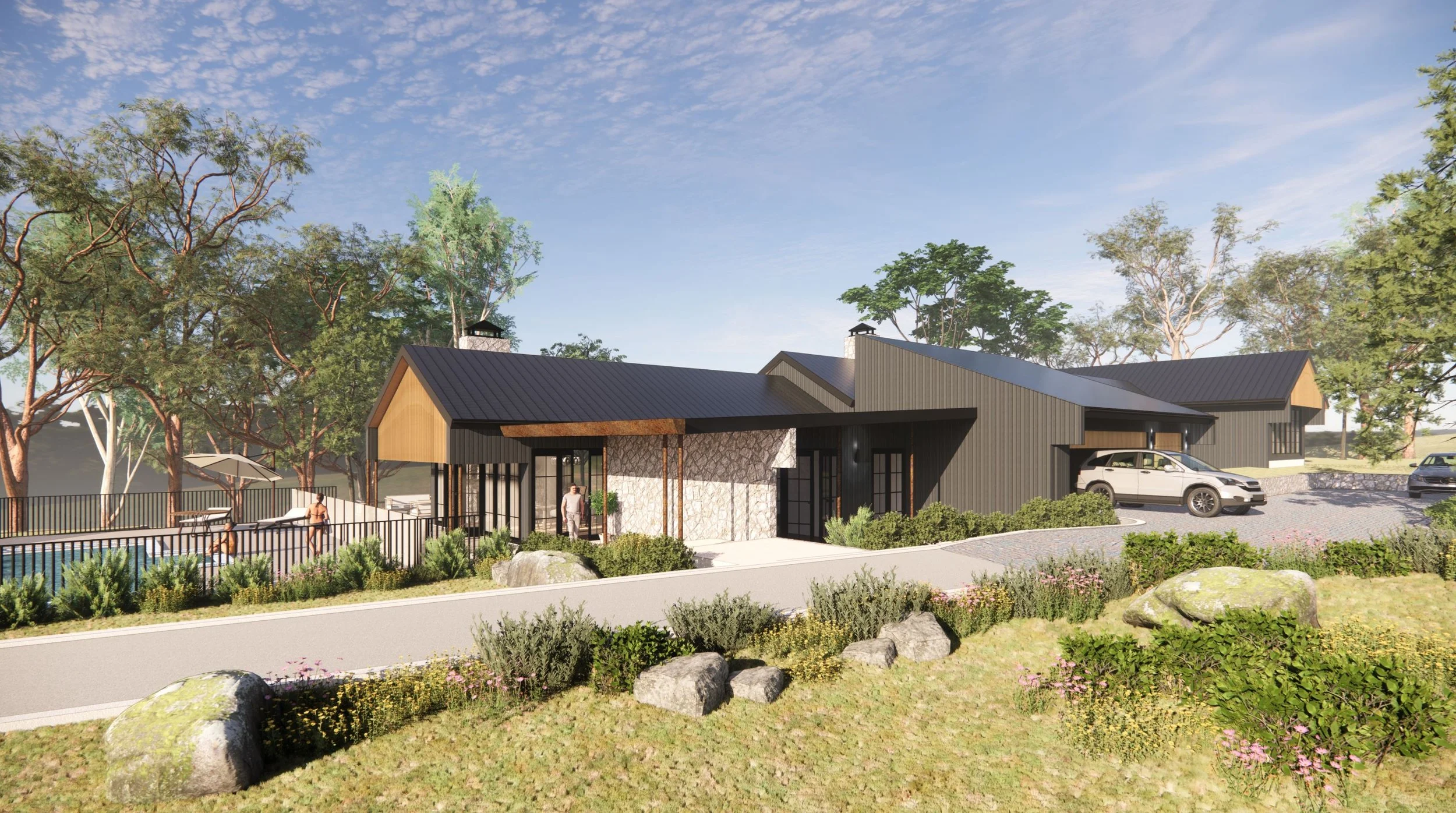 A modern single-story building with black metal siding, a dark metal roof, and a stone accent wall. There are driveways with parked cars, a landscaped yard with rocks and bushes, and trees in the background.